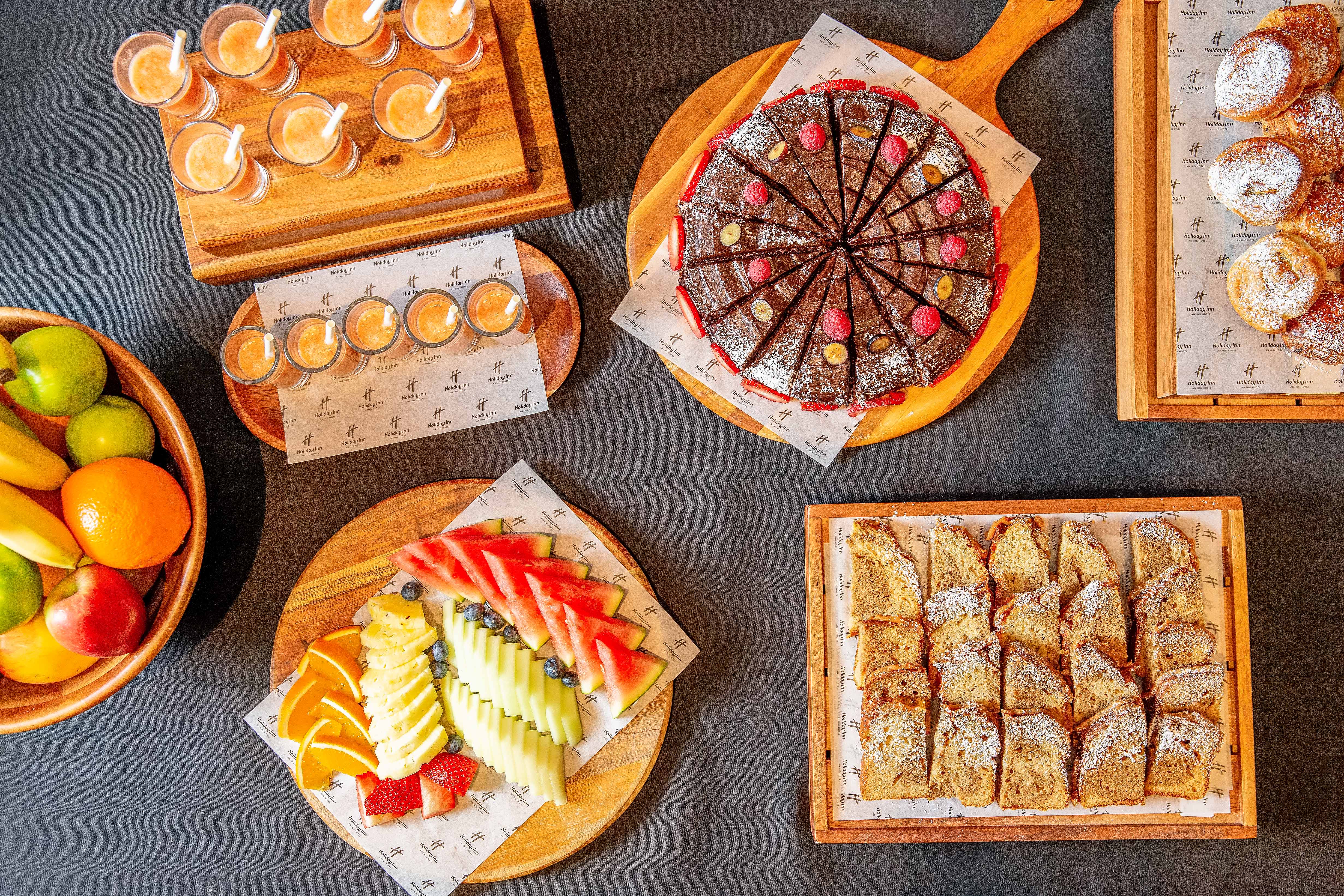 Catering spread with vibrant fruit and pastries at Holiday Inn Kensington for events.