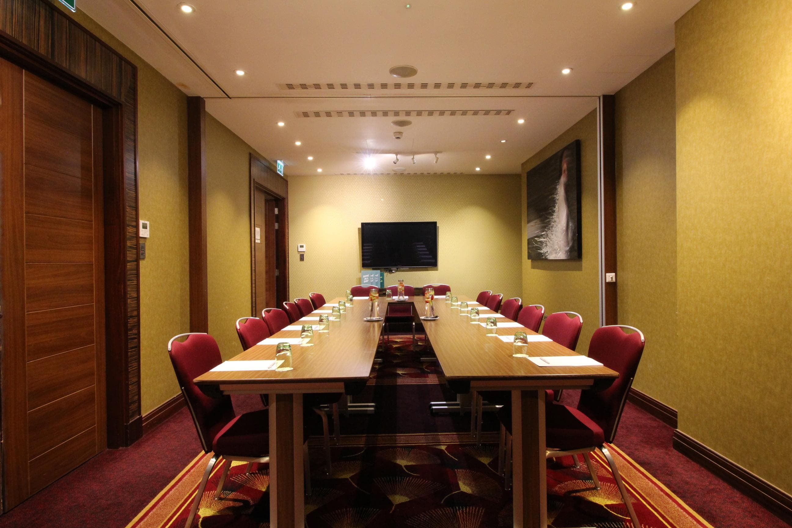 St James Suite at Holiday Inn Kensington, formal meeting room with wall-mounted screen.