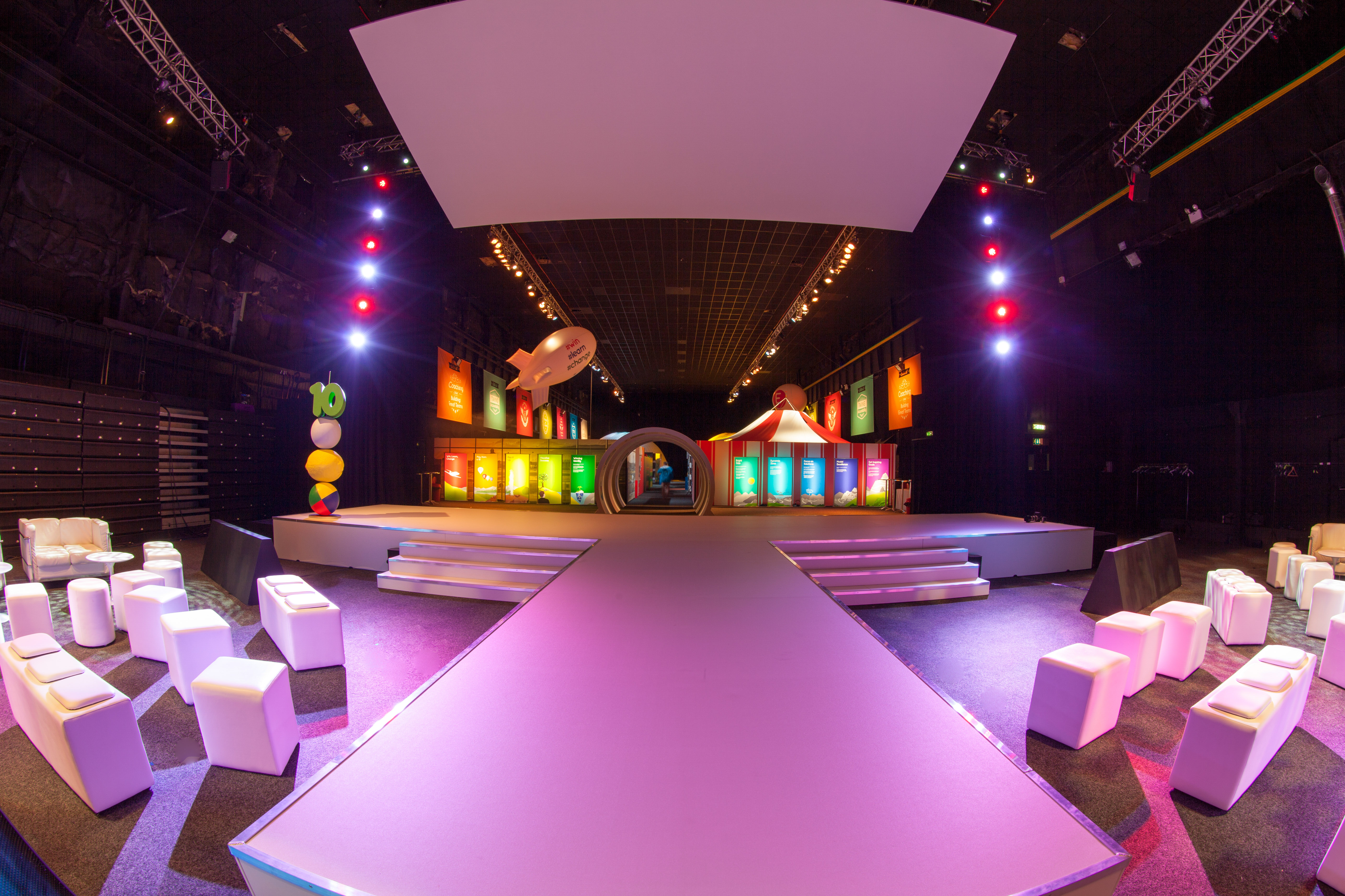 Vibrant event space in The Big Hall, MAGNA, with colorful stage and modern seating.