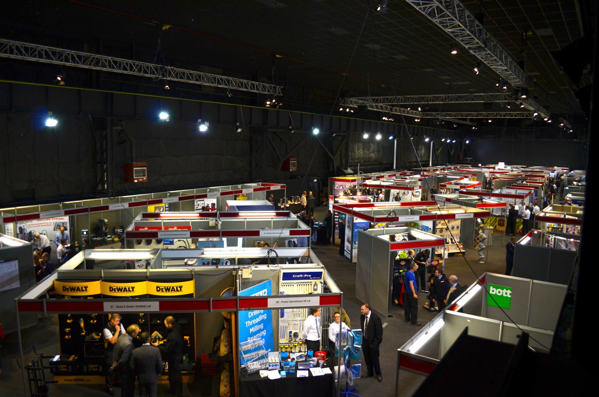 Busy exhibition hall in MAGNA with vendor booths for networking and collaboration.