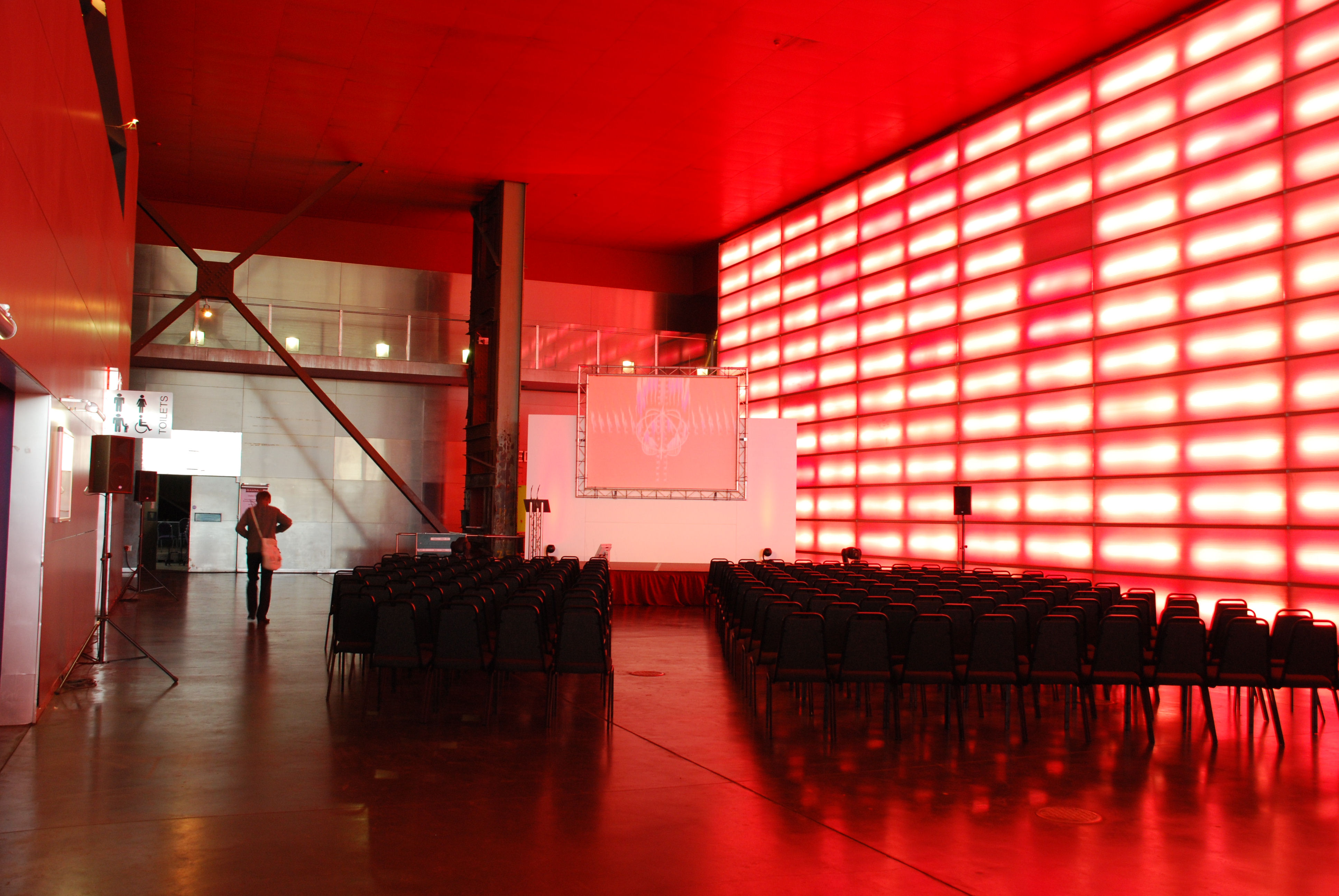 Modern event space in The Red Hall, featuring a striking red wall for presentations.