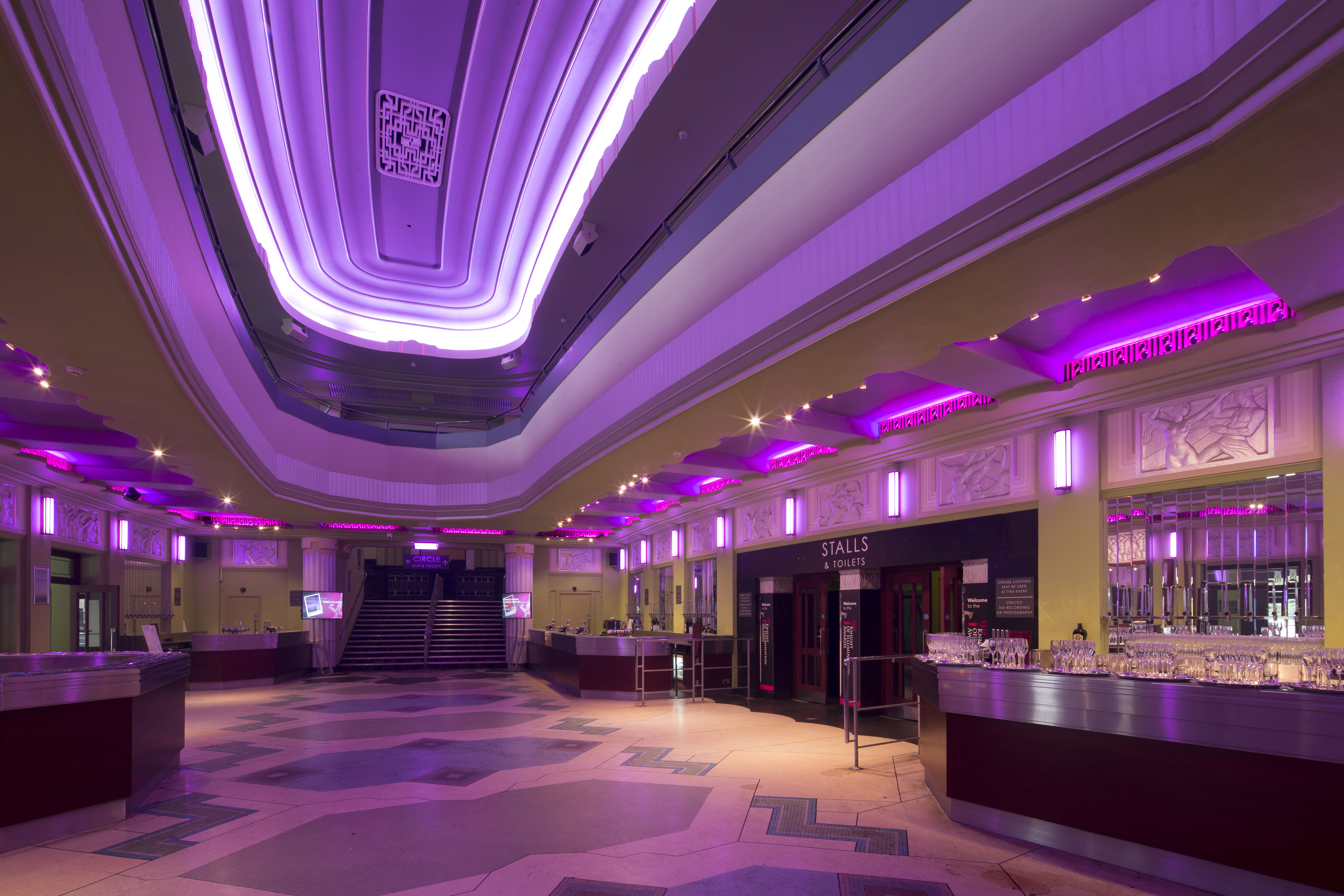 Elegant art deco venue with purple lighting, perfect for conferences and social gatherings.