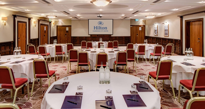 Isaac Newton suite at Hilton Cambridge, ideal for corporate events with round tables.