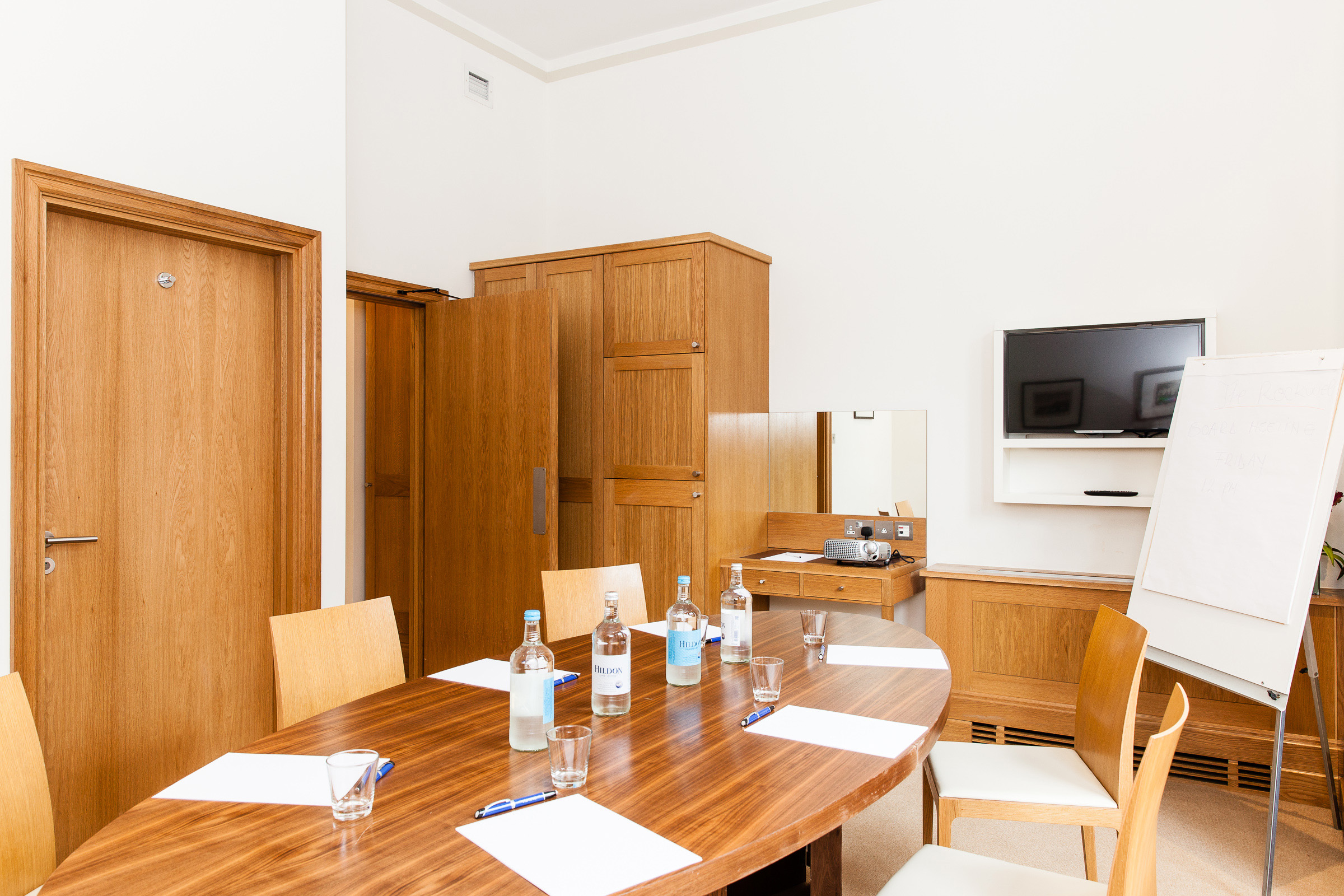 Meeting room with round table, ideal for workshops and small gatherings.