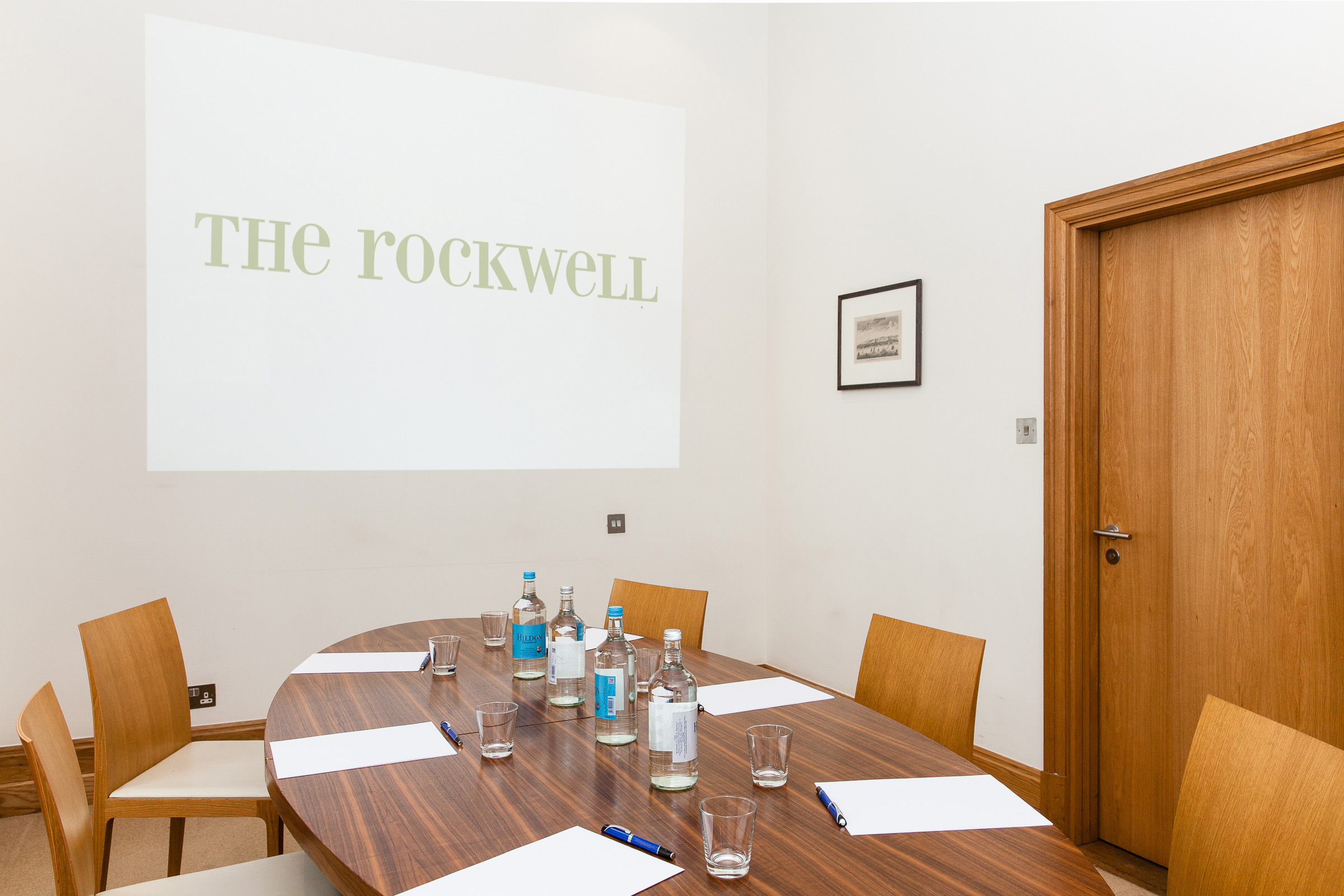 Meeting room with oval table, ideal for corporate events and gatherings.