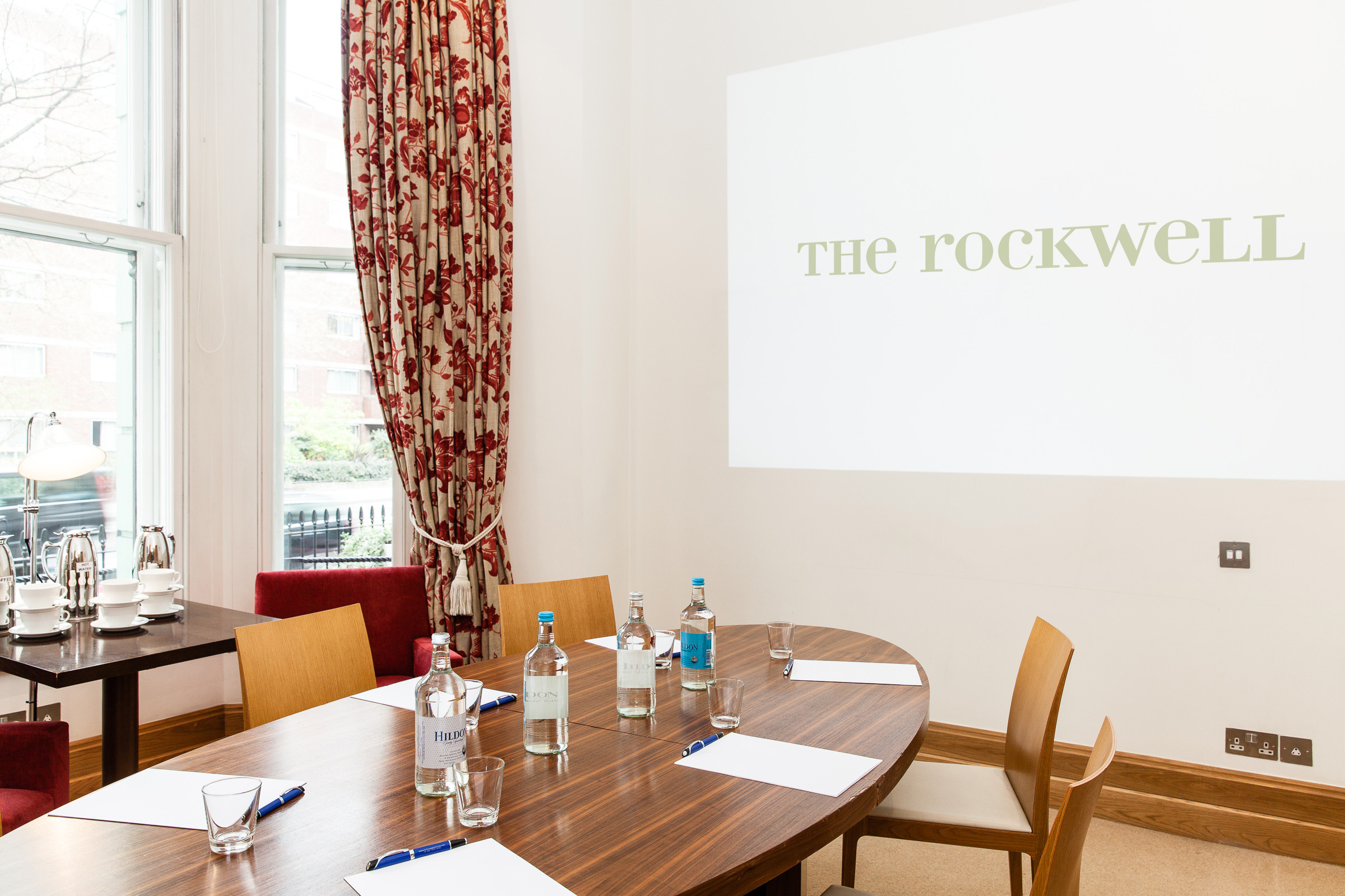 Bright meeting room at The Rockwell with round table, ideal for events and presentations.