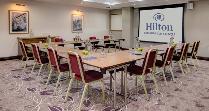 Byron suite meeting room at Hilton Cambridge, featuring rectangular tables for collaboration.