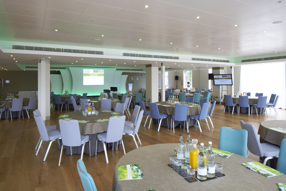 Thames View Suite at The Lensbury, modern meeting space with blue chairs and AV tech.