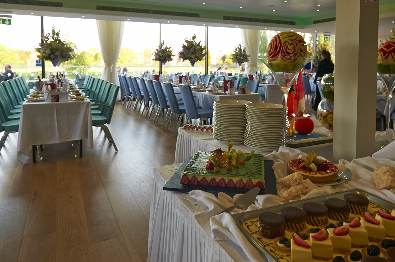 Thames View Suite at The Lensbury, elegant event space with floral centerpieces and pastries.