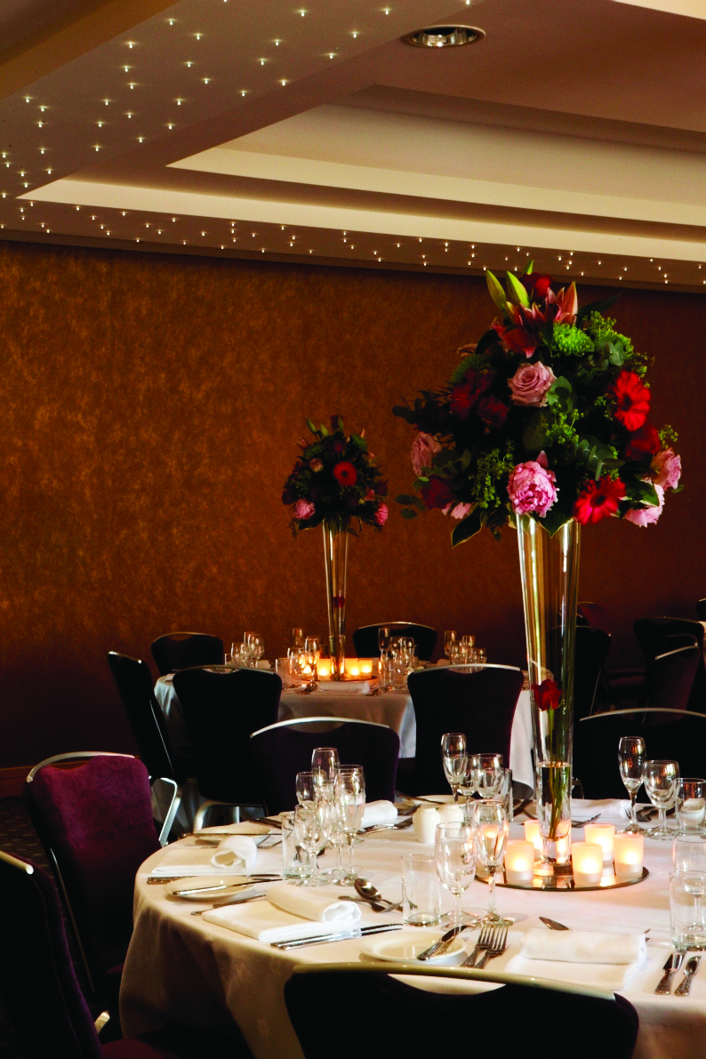 Elegant dining table with floral centerpieces in Wimbledon Room, perfect for upscale events.