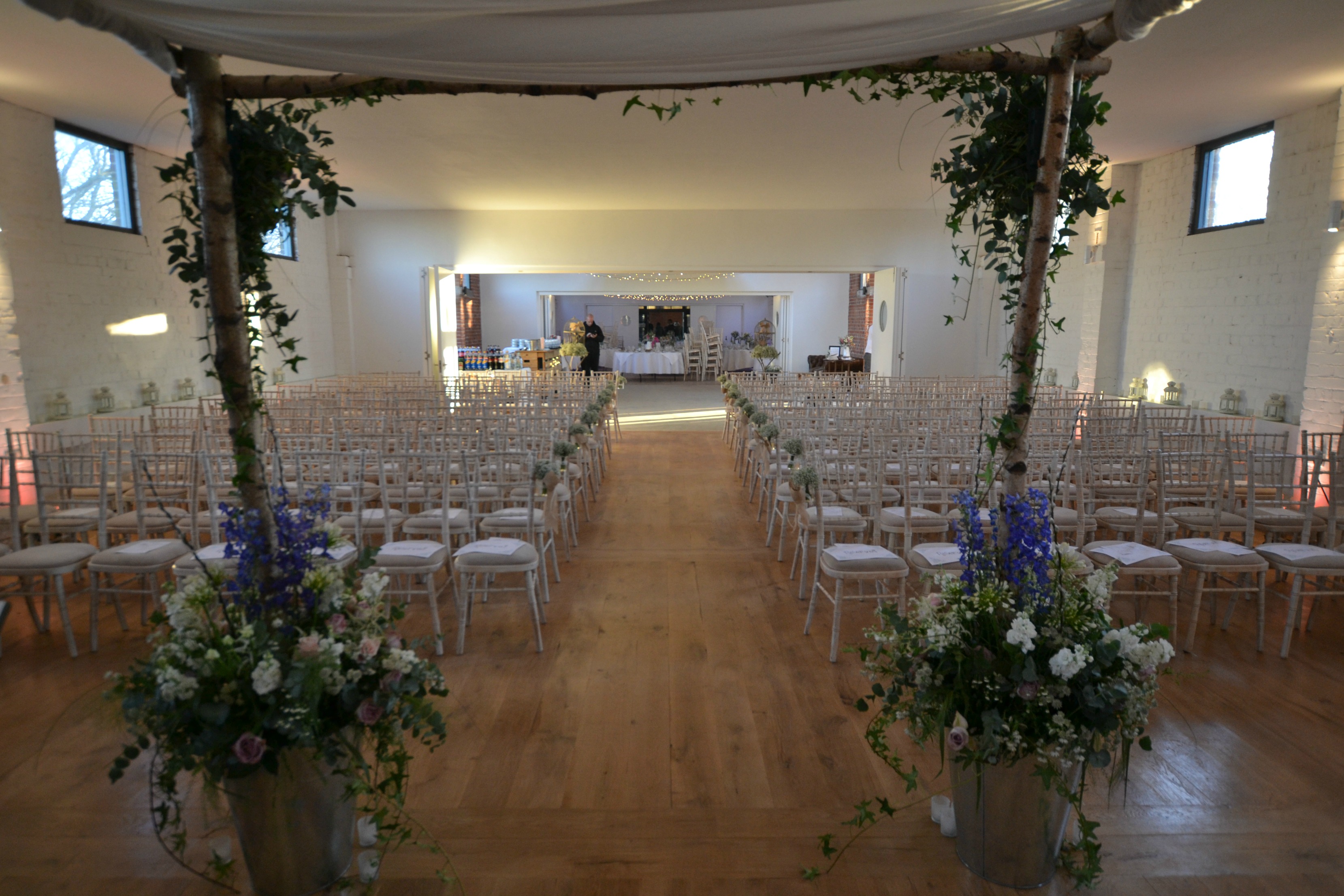 Elegant wedding setup at The Bomb Factory, featuring floral decor and chiavari chairs.