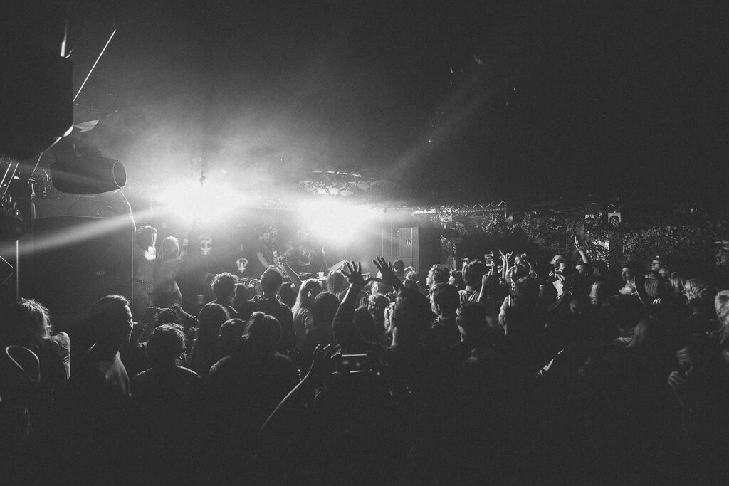 Vibrant crowd at The Bomb Factory, Osea Island, during a live event with dynamic lighting.