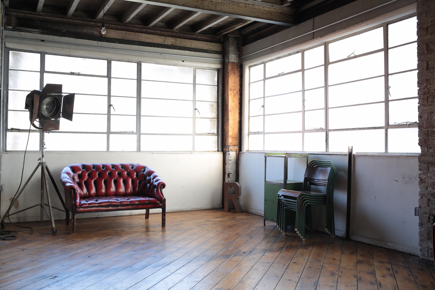 Stylish industrial venue with vintage red sofa for creative meetings and workshops.