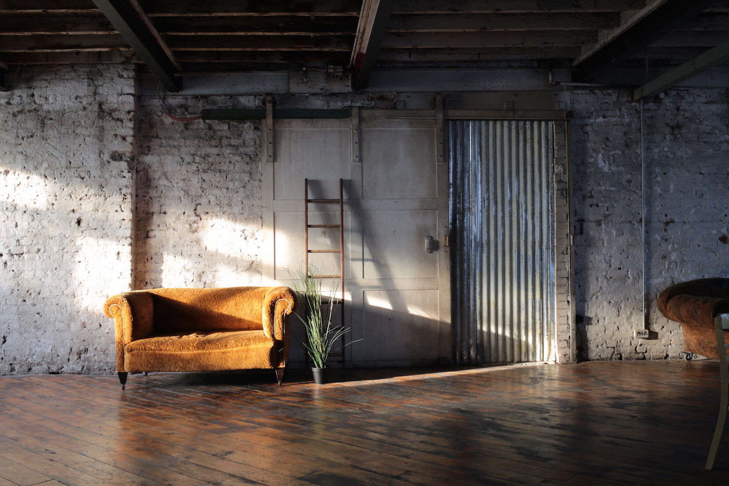 Rustic venue at Belt Craft Studios with vintage sofa, ideal for intimate gatherings and workshops.