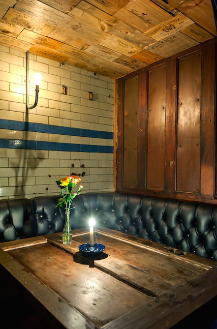 Intimate wine bar with leather banquette, perfect for networking events and gatherings.