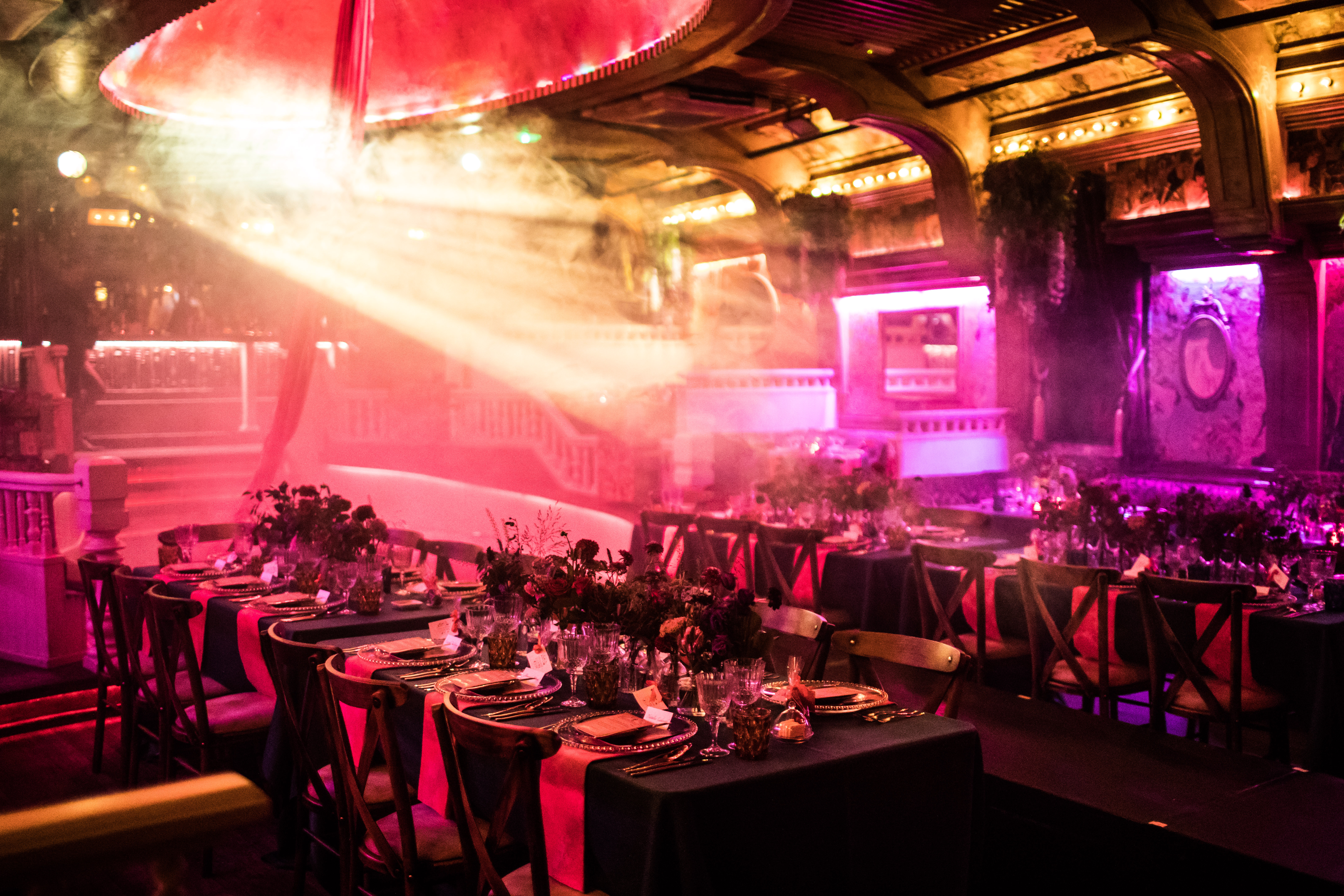 Elegant event space in The Box Soho with dark linens and vibrant florals for upscale gala.