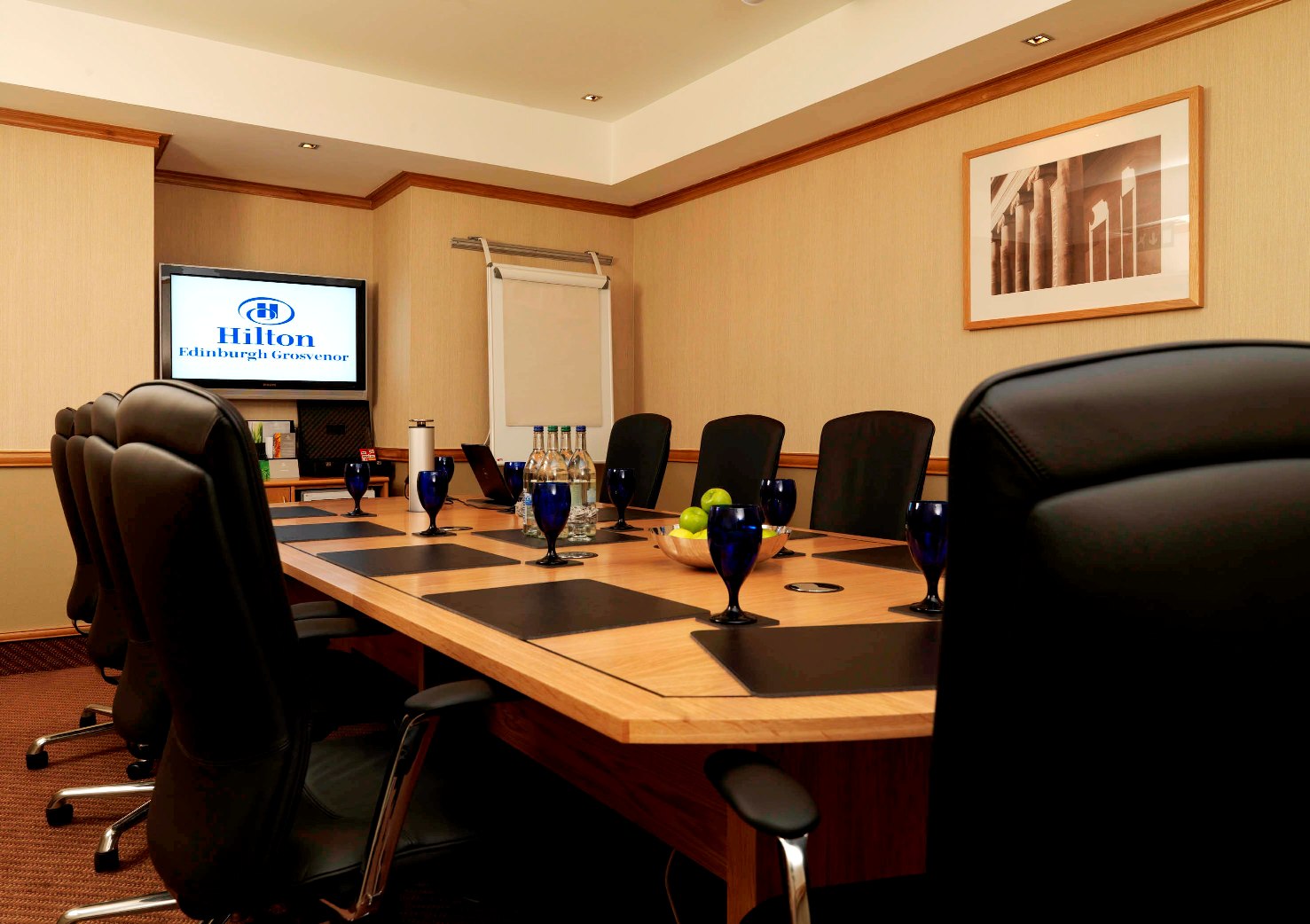 Boardroom at Edinburgh Grosvenor Hotel with sleek table, ideal for corporate meetings.