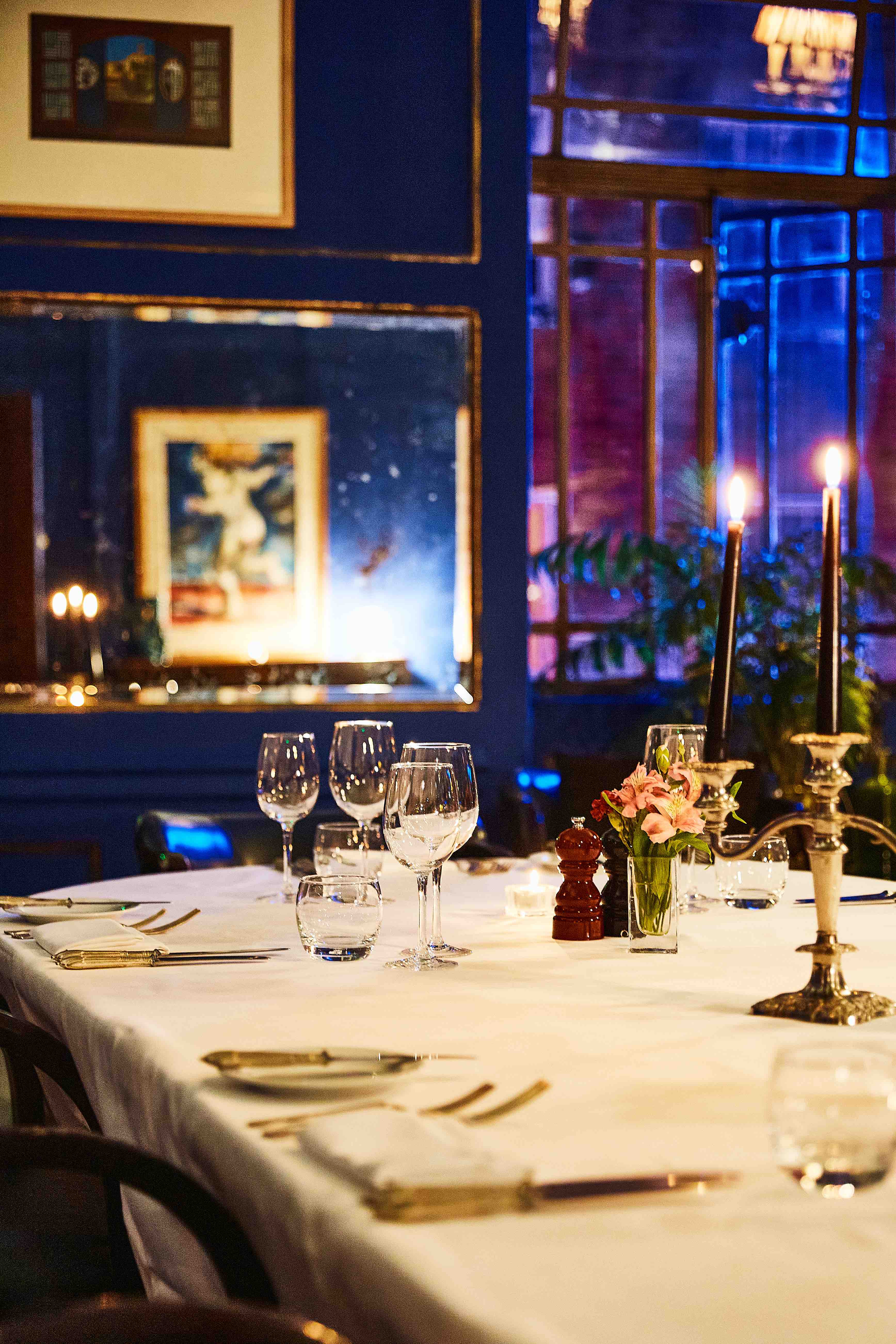 Elegant L'Escargot gala dinner setting, candlelit, floral.