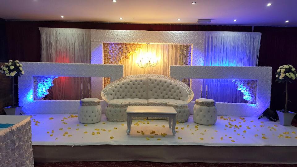 Elegant event stage with white tufted sofa, ideal for weddings and upscale gatherings.