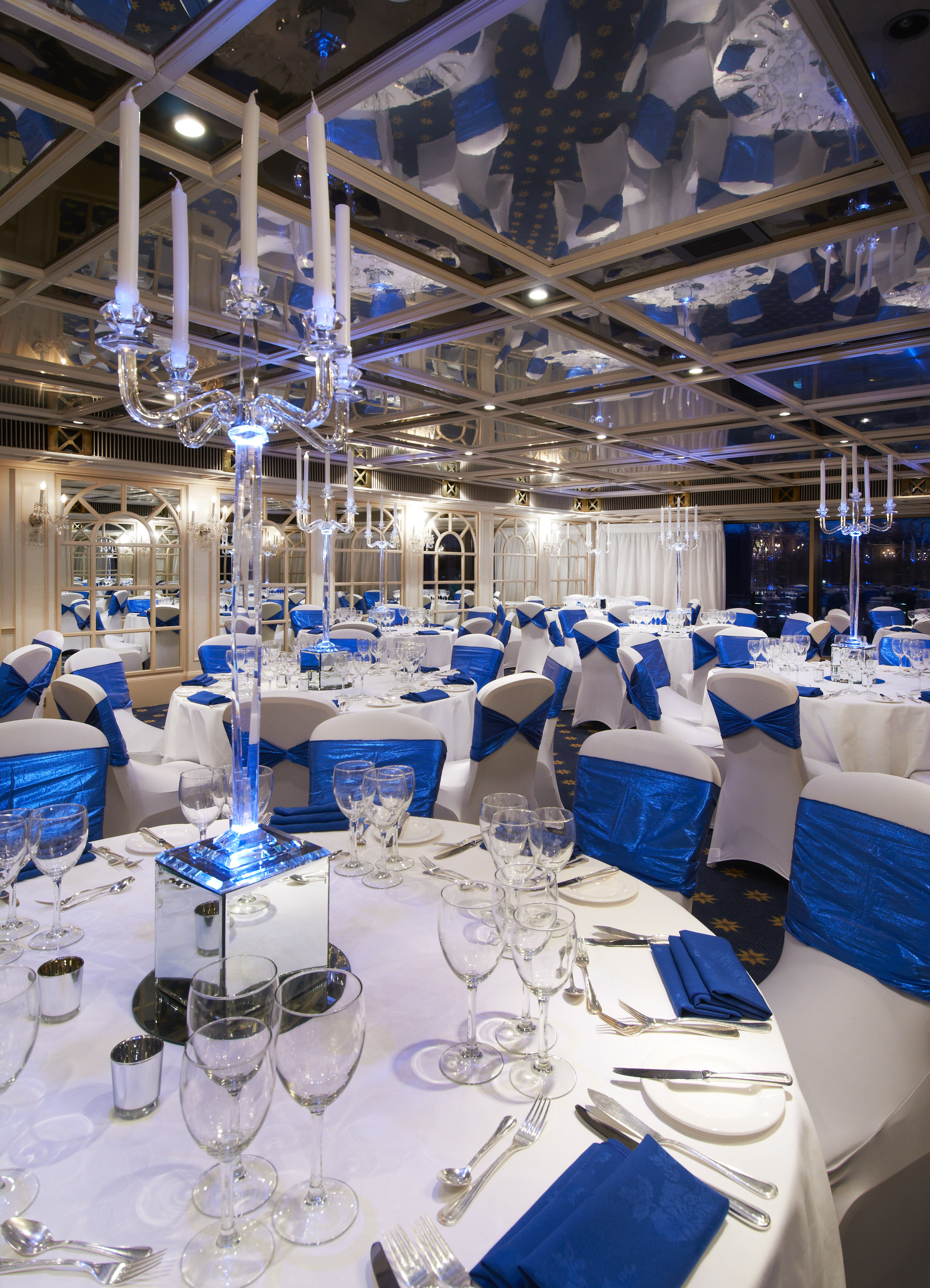 Elegant banquet hall at Crystal Palace, London, with white linens and blue sashes for upscale events.