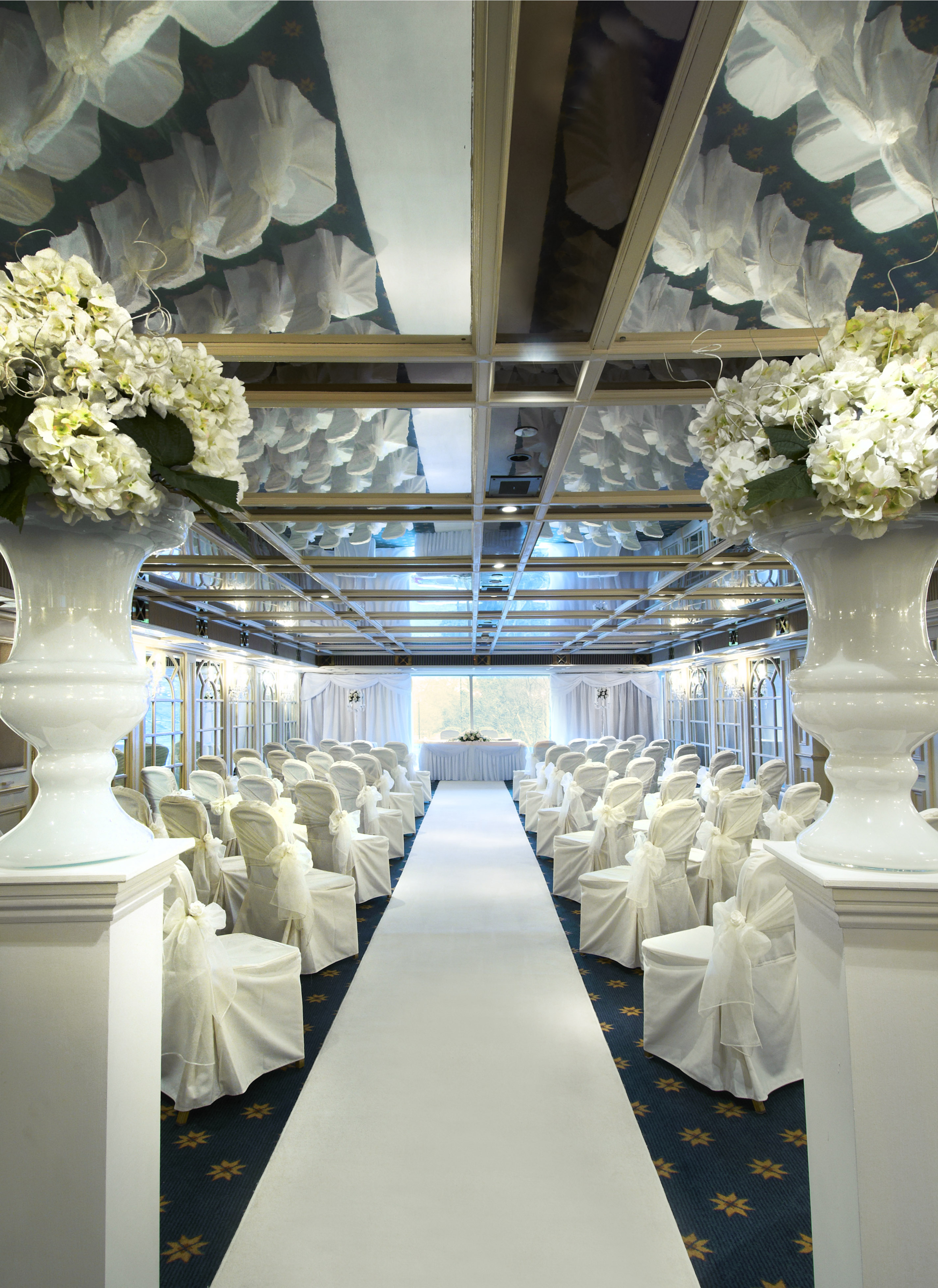 Elegant wedding venue at Crystal Palace, featuring white chairs and floral centerpieces.