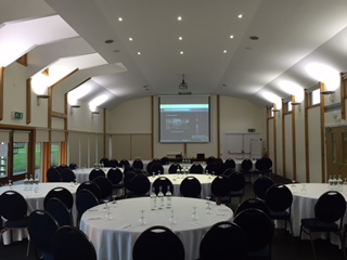Astor Pavilion event space with round tables, ideal for conferences and workshops.