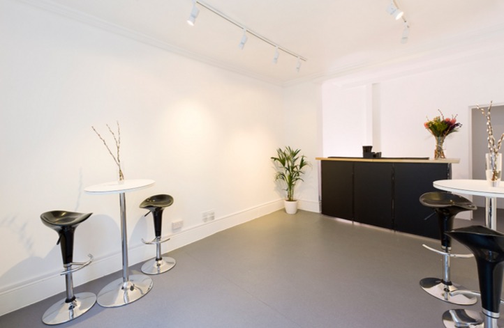 Sleek minimalist event space with high-top tables for networking and cocktail receptions.