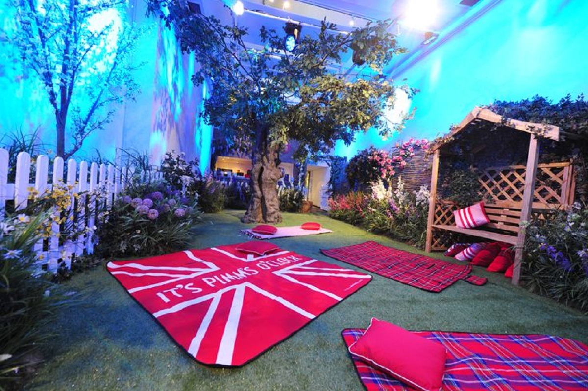 Whimsical British-themed event space with artificial grass and cozy seating for gatherings.
