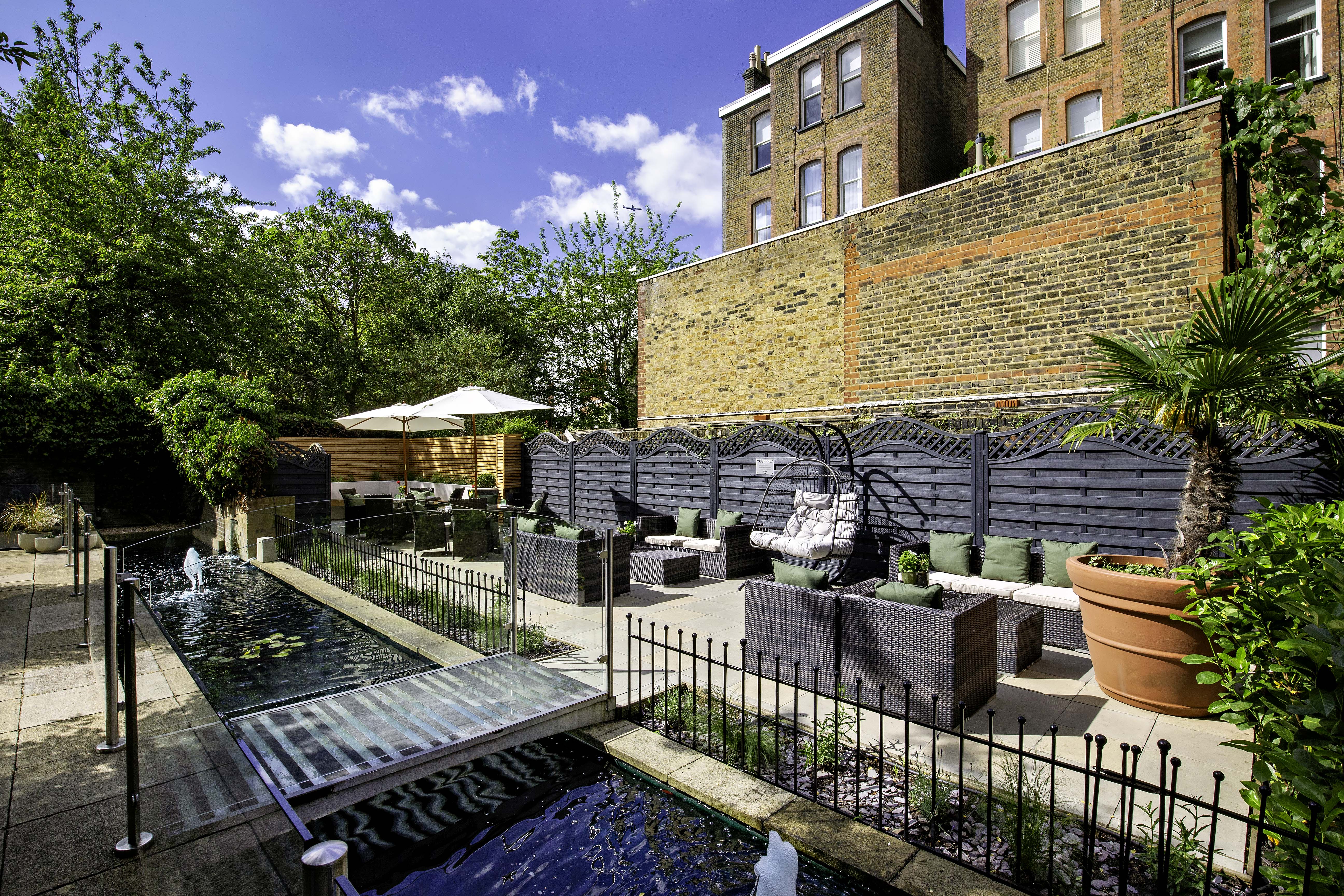 Serene outdoor garden at Holiday Inn Kensington, ideal for events and gatherings.