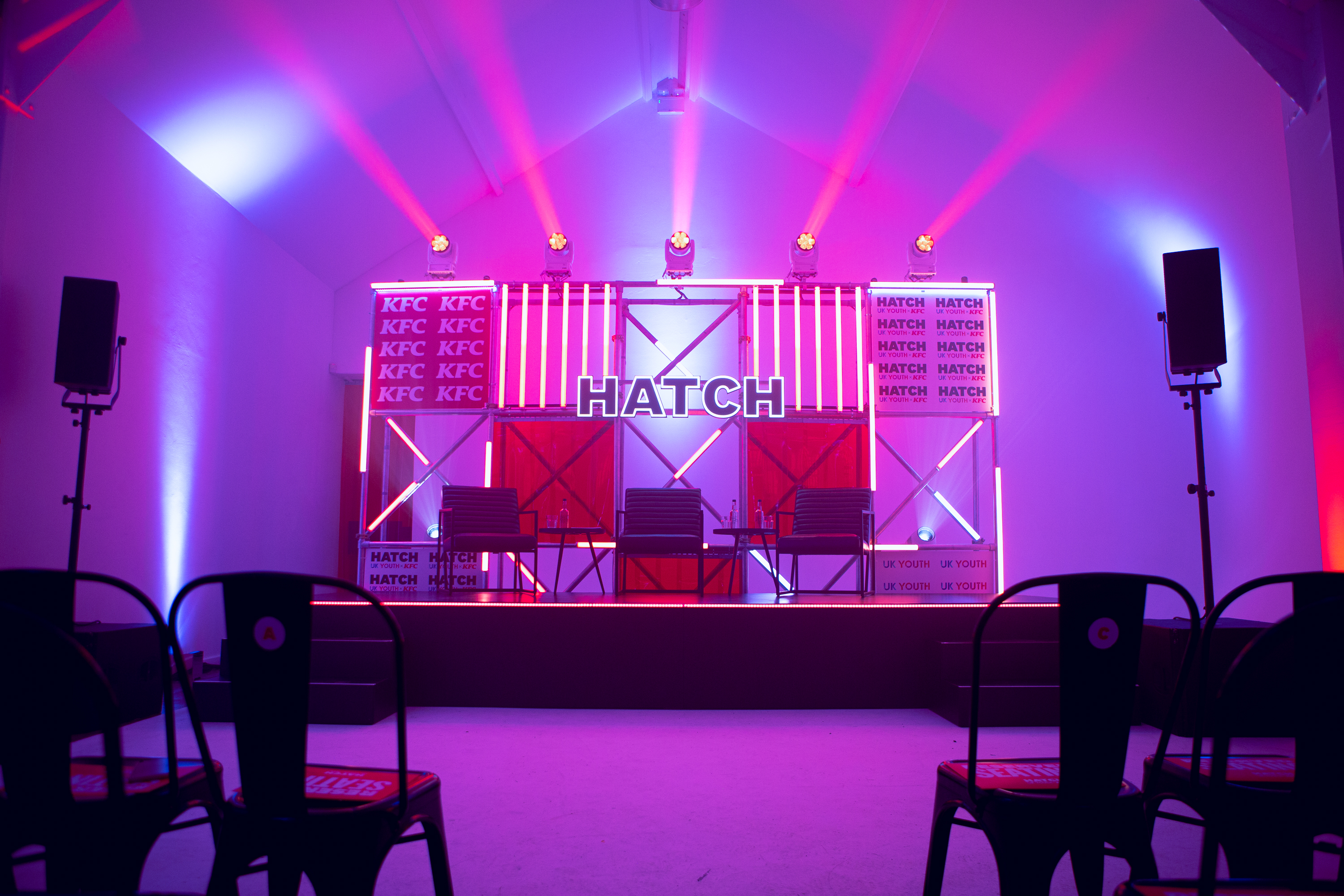 Vibrant event stage with bold lighting for panel discussion at FiveFour Studios.