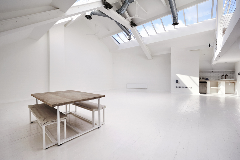 Bright minimalist event space with natural light for meetings and workshops.