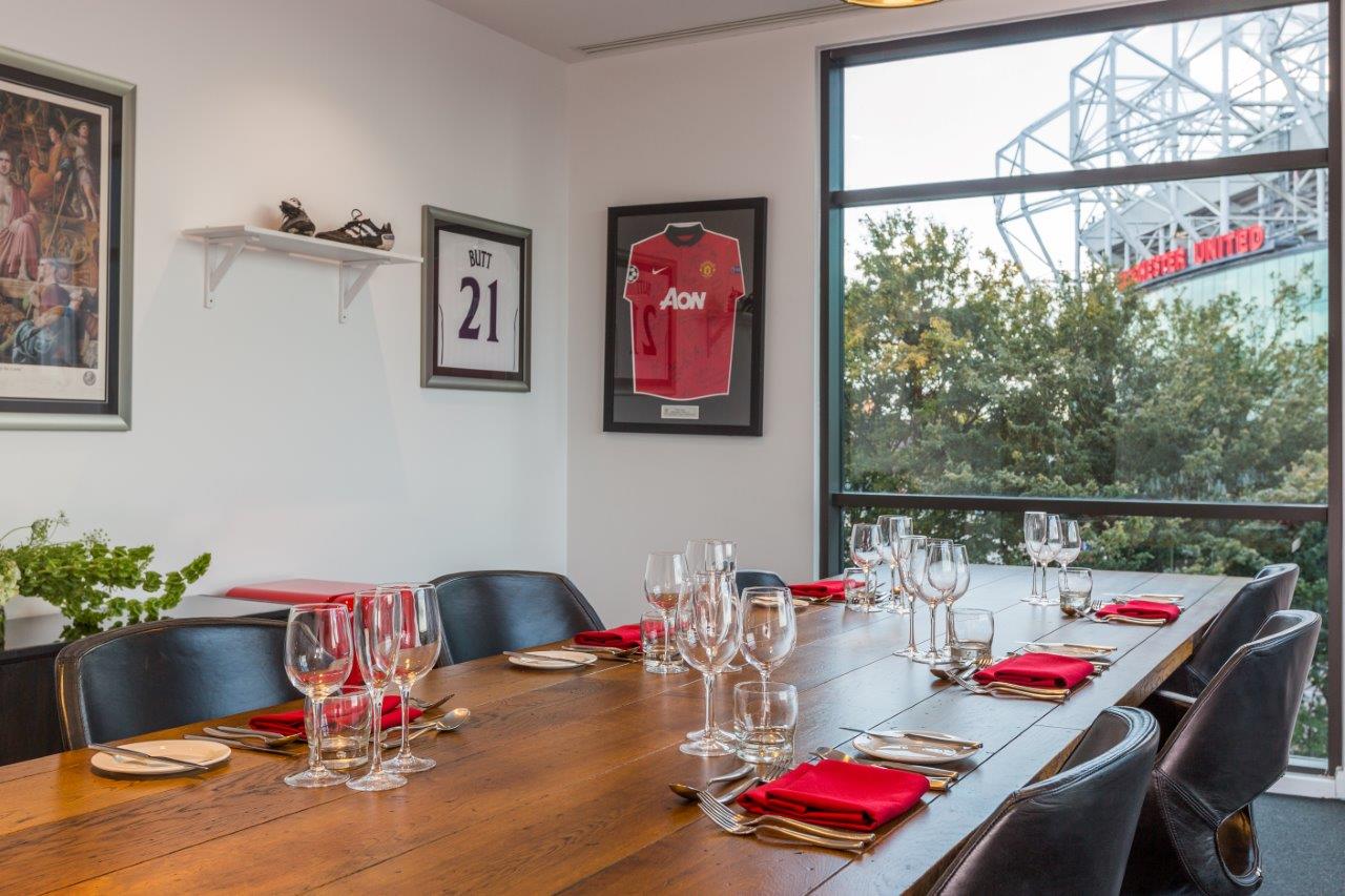 Stylish meeting room at Hotel Football with wooden table, ideal for corporate events.