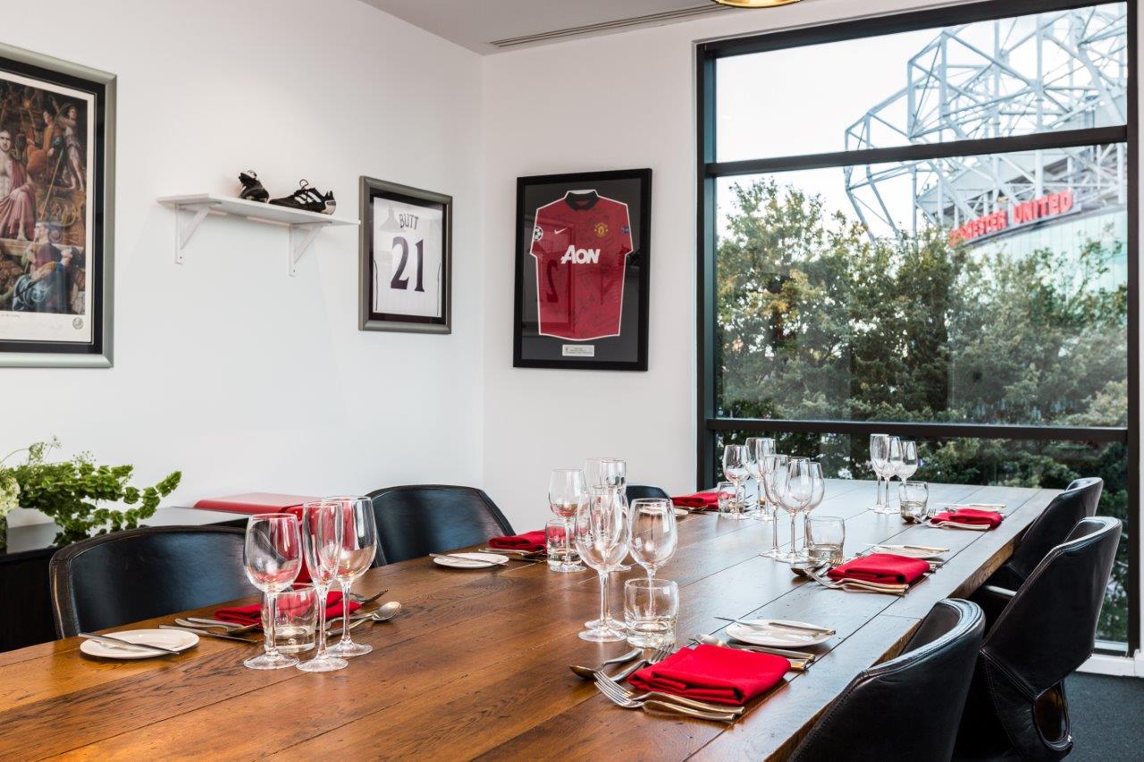 Stylish meeting room at Hotel Football with wooden table, ideal for corporate events.