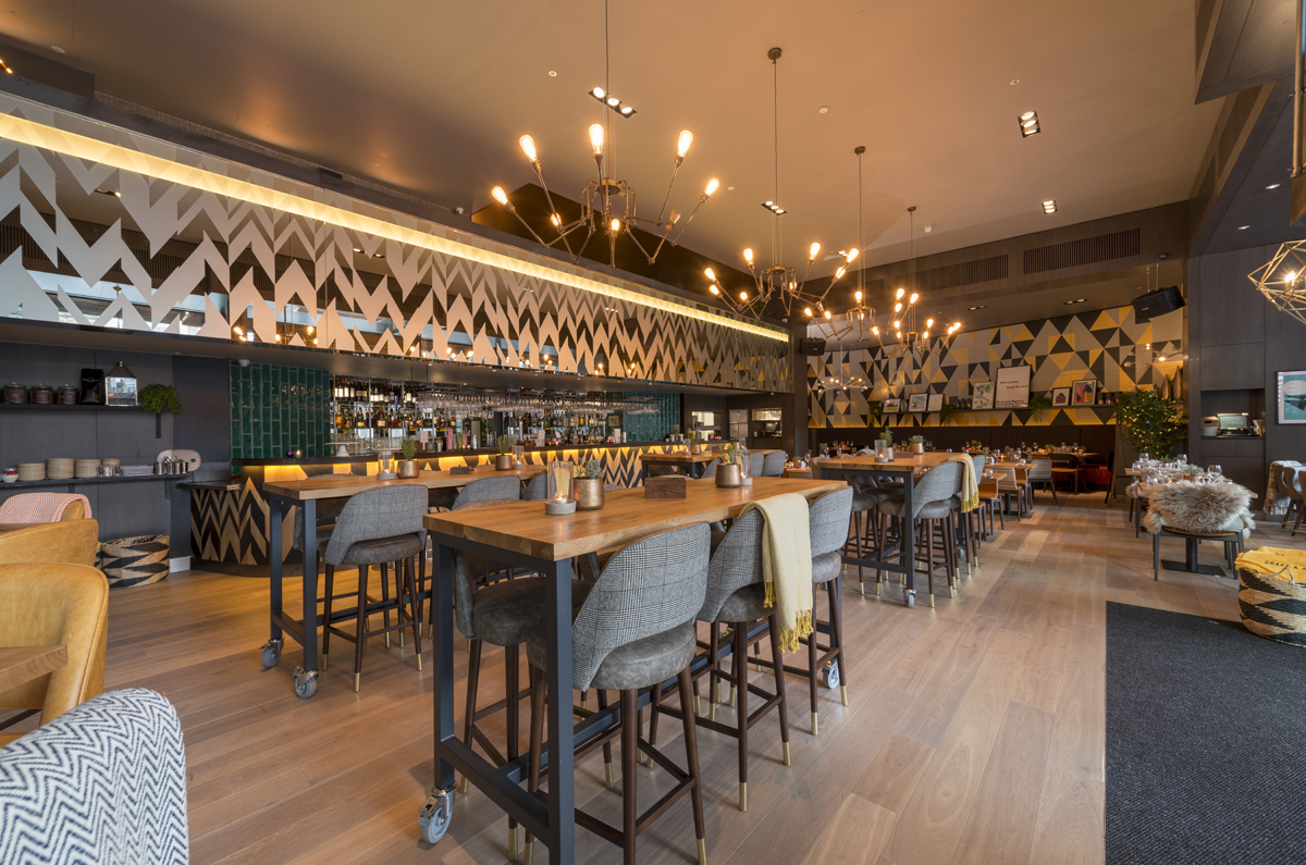 Modern event venue with sleek wooden tables and vibrant decor at The Refinery New Street Square.