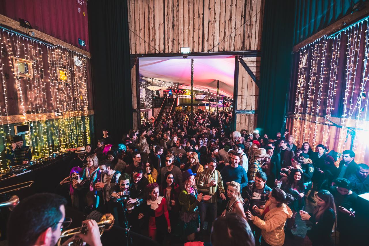 Vibrant event space in Pop Brixton with lively crowd and warm string lights.