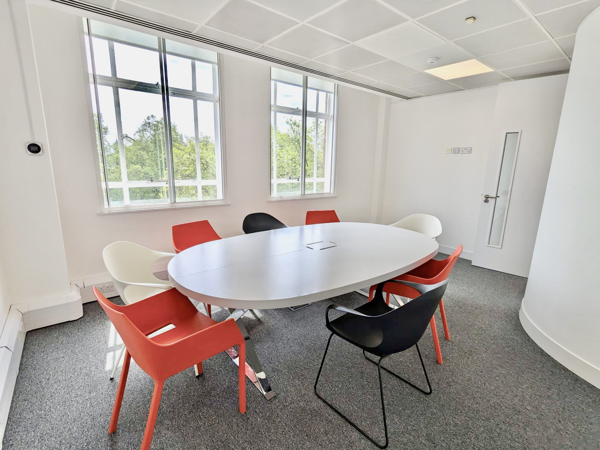 Modern meeting room for 8 with oval table, ideal for brainstorming sessions.