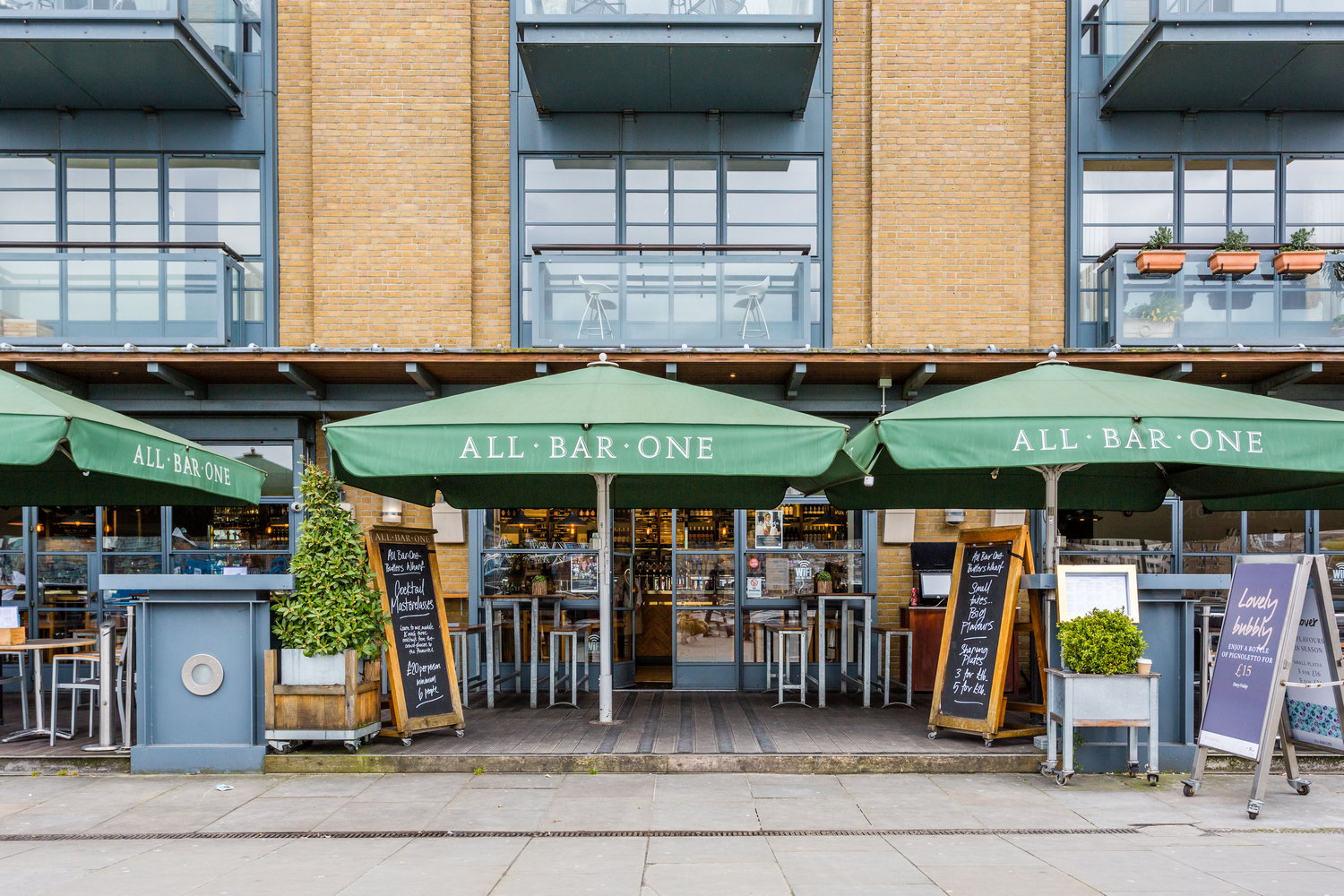 Outdoor dining at All Bar One Butlers Wharf with green umbrellas for casual events.