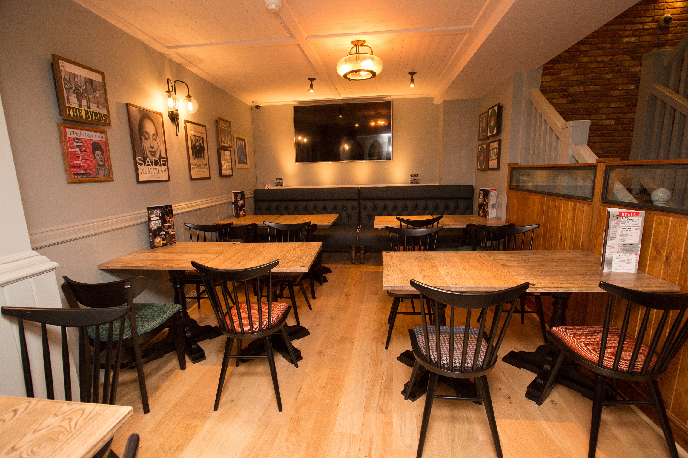 Versatile event space at O'Neill's Wardour Street with wooden tables for gatherings.
