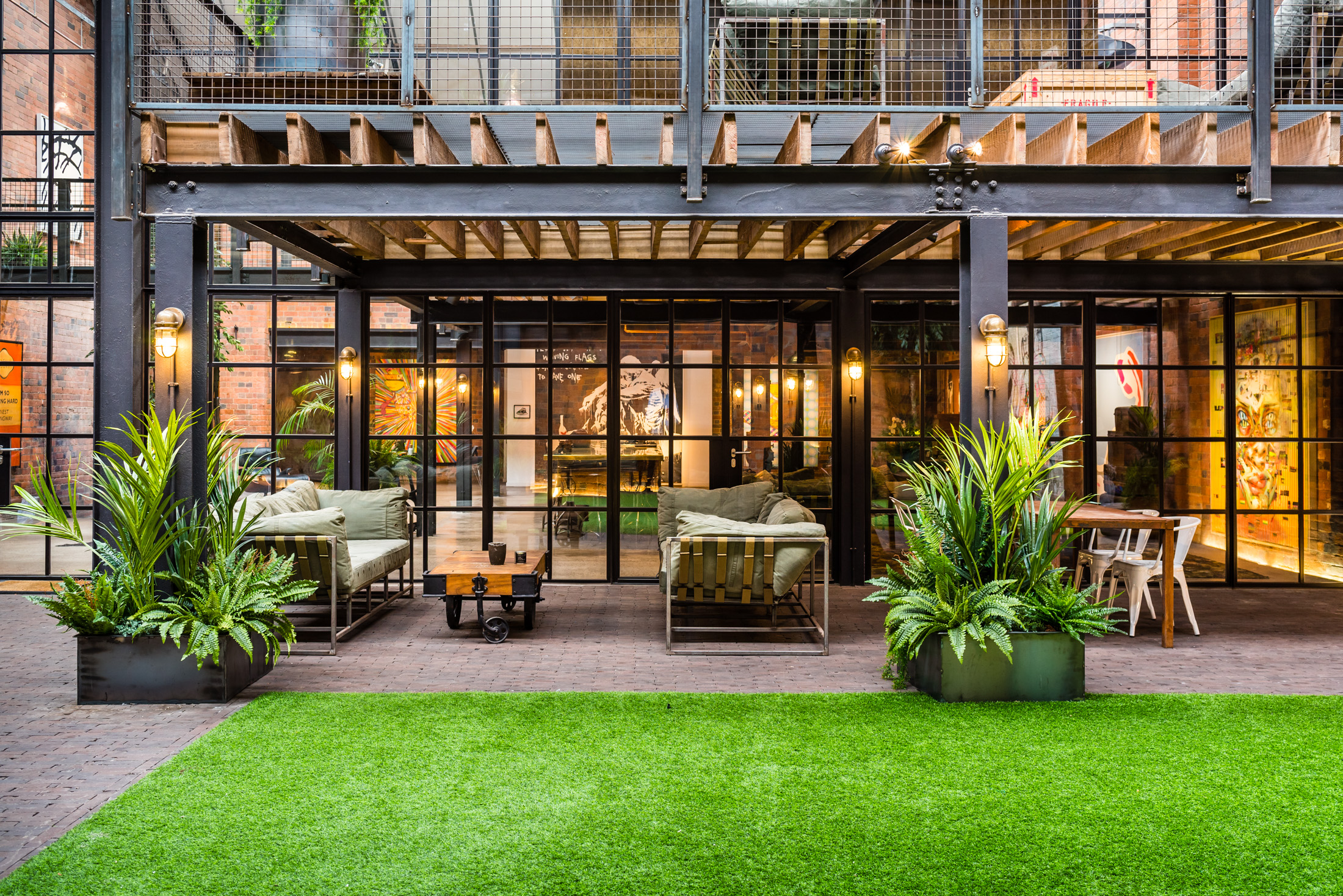 Stylish outdoor meeting space with glass walls for networking and events in The Compound.