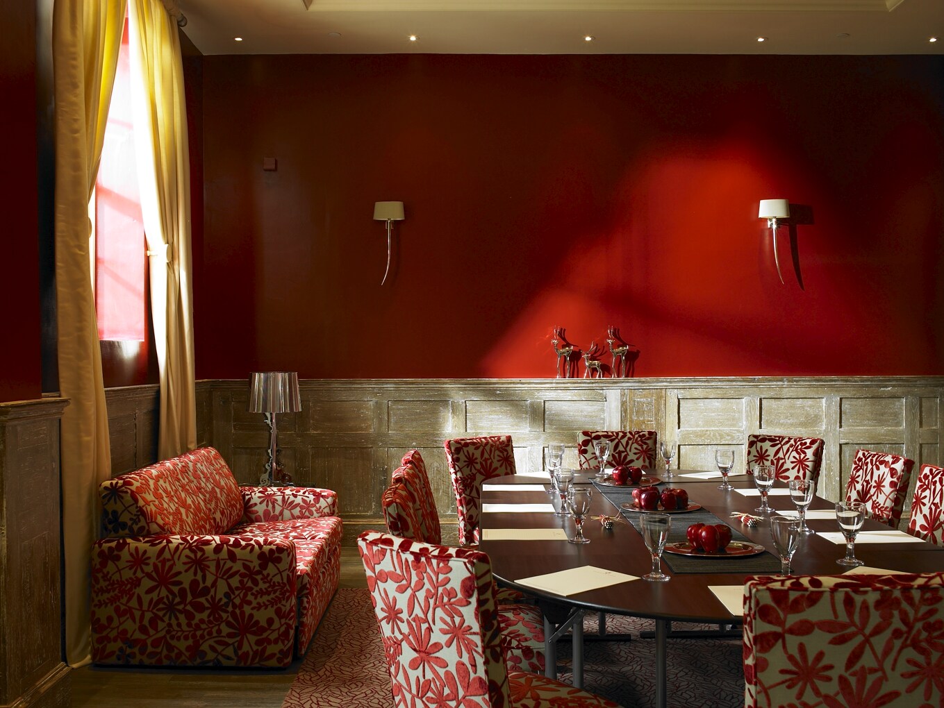 Stylish meeting room with red walls at Fawsley Hall Hotel for events and gatherings.