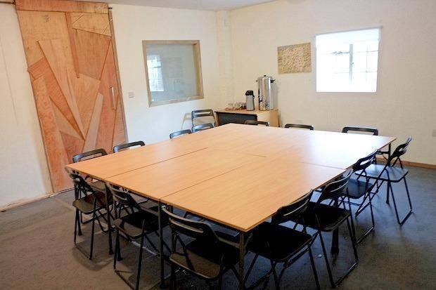 Versatile meeting room with central table, ideal for workshops and brainstorming sessions.