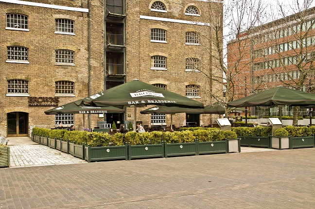 Outdoor meeting space with seating and greenery at Browns West India Quay for networking events.
