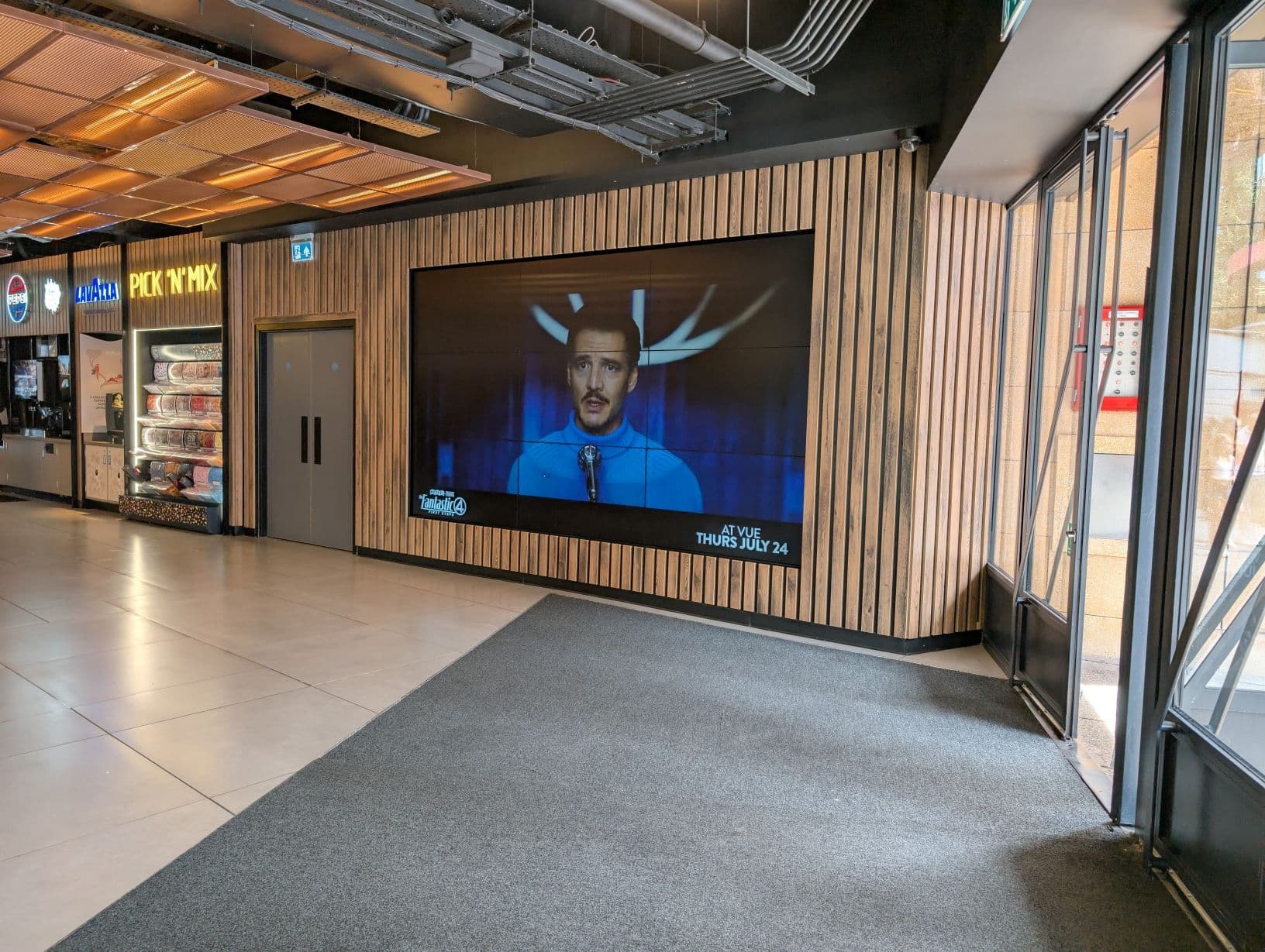 Vue West End cinema lounge with modern LED digital signage and wood decor for corporate events.