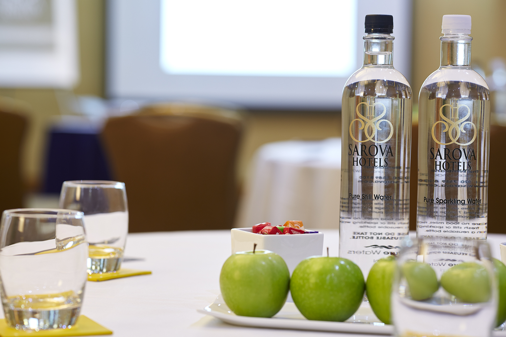 Elegant meeting setup in Edward Suite with fresh apples and water bottles.