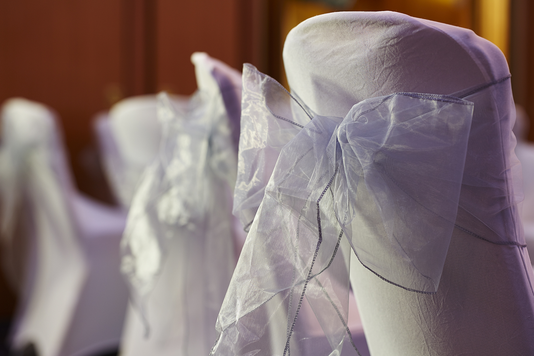 Elegant chair covers with sheer bows in Edward Suite, perfect for weddings and formal events.