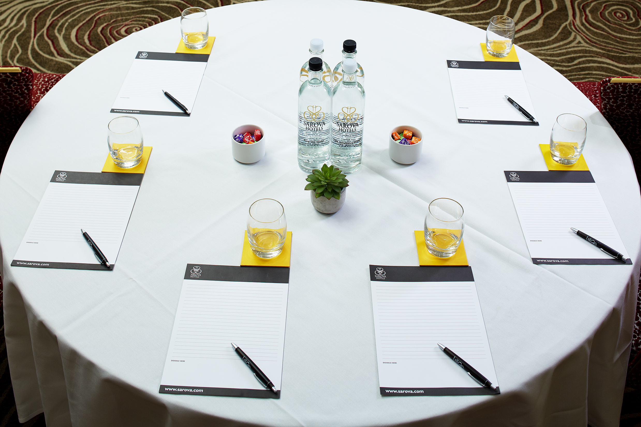 Charles Suite meeting setup with round table, notepads, and succulents for collaboration.