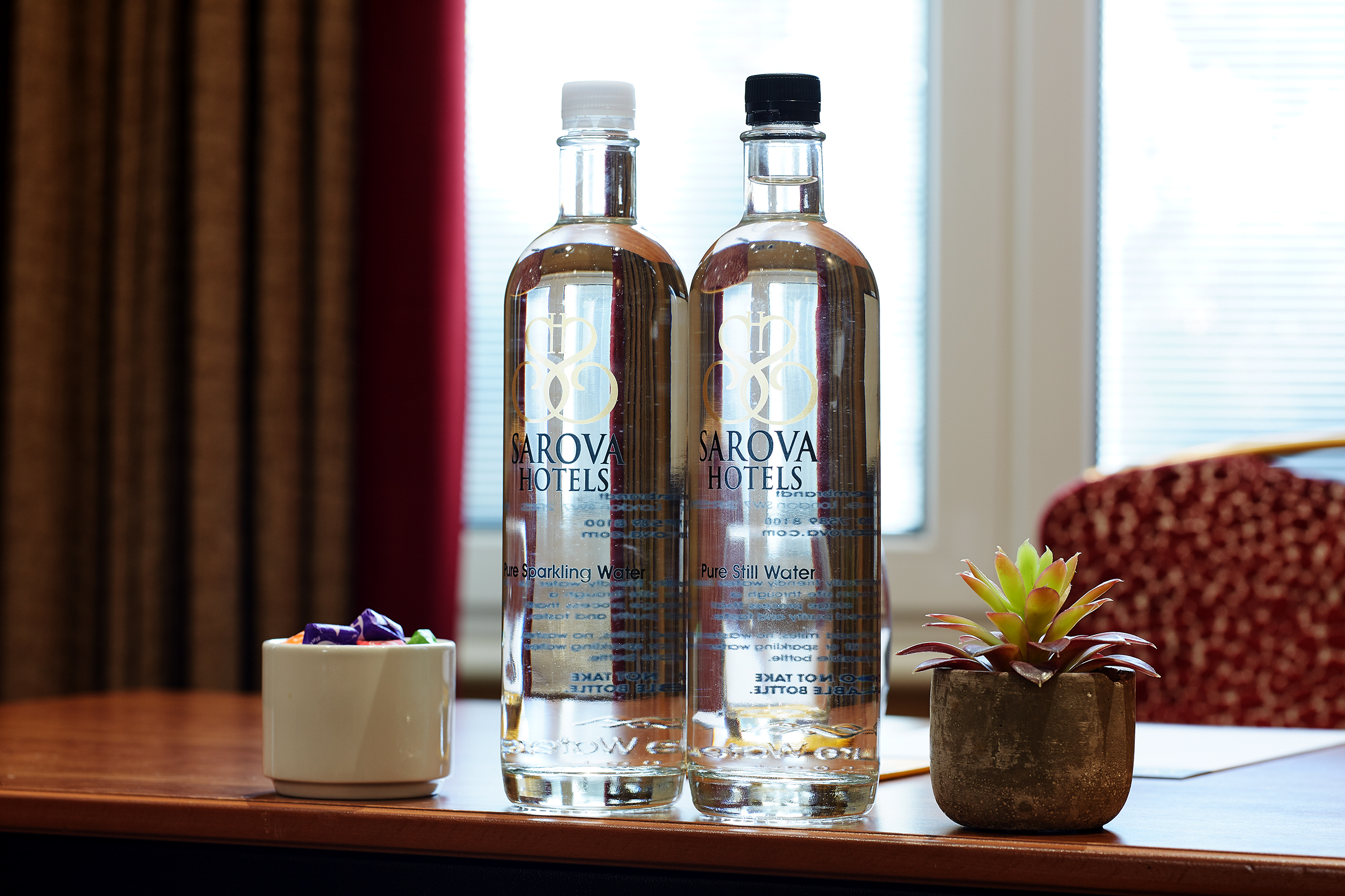 "Elizabeth suite meeting setup with water bottles, succulent, and colorful cup for events."