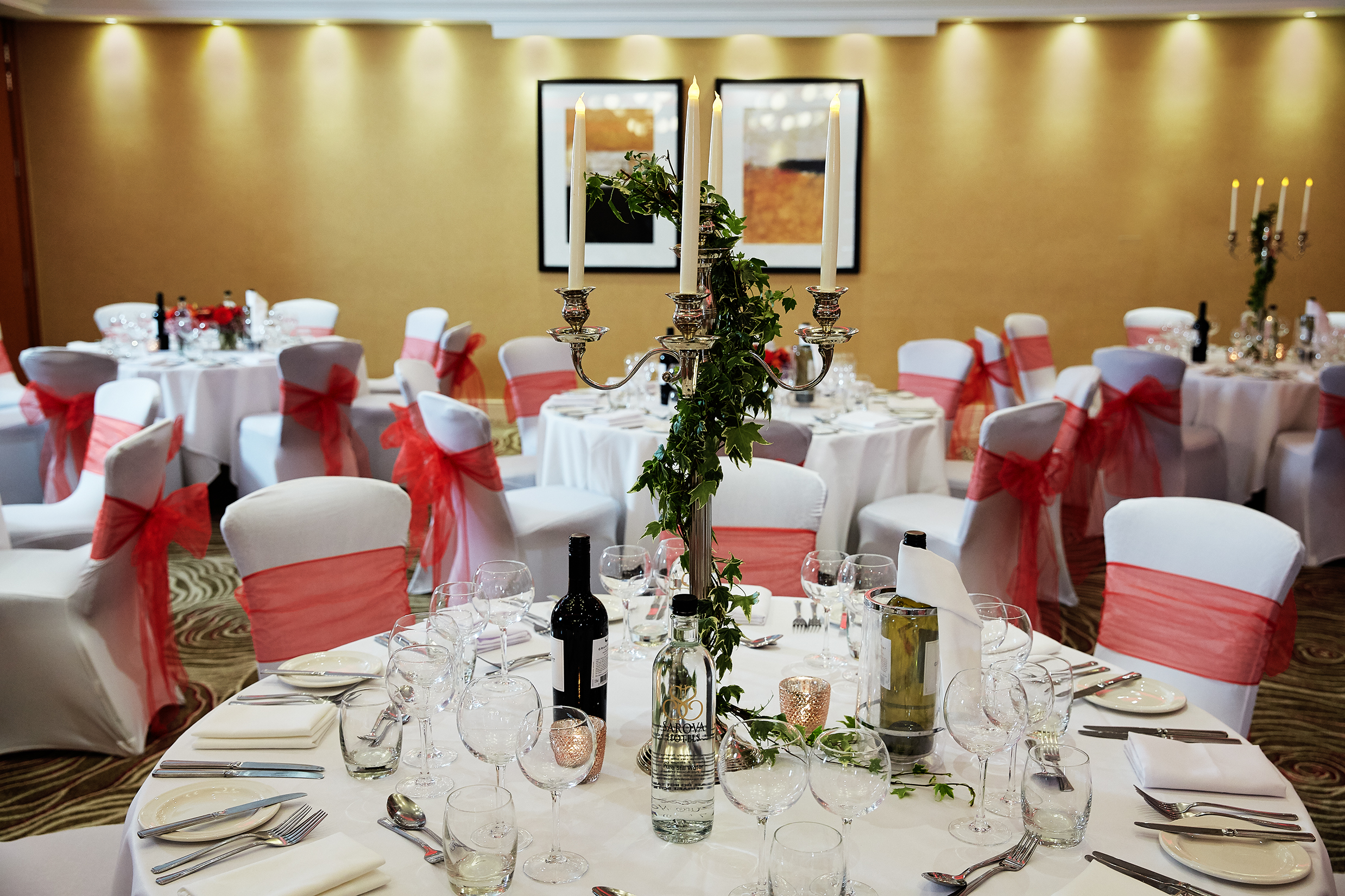 Elegant banquet setup with white linens and pink sashes for weddings and formal events.