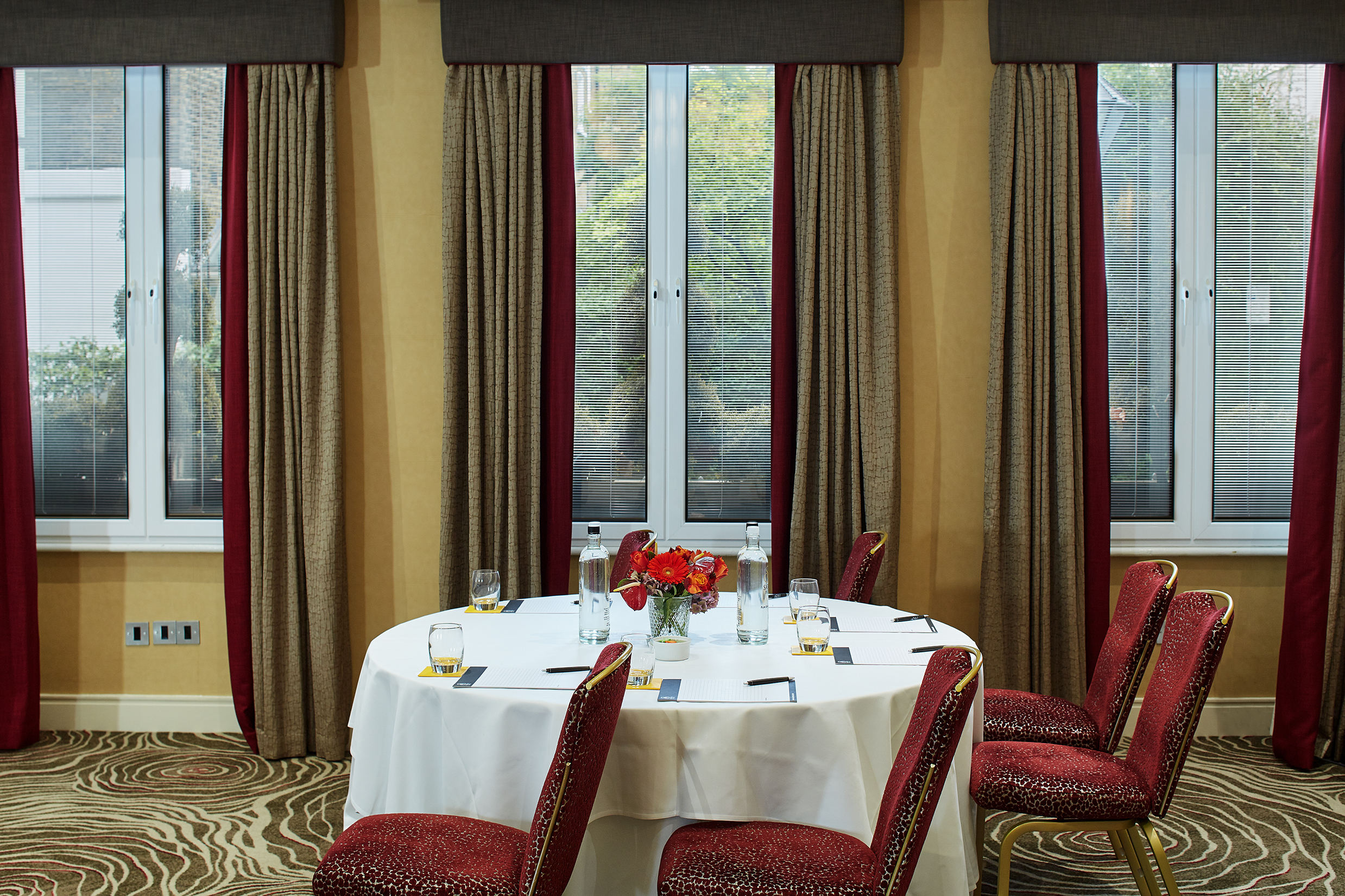 "Elegant meeting space with round table for intimate gatherings at The Rembrandt Suites."