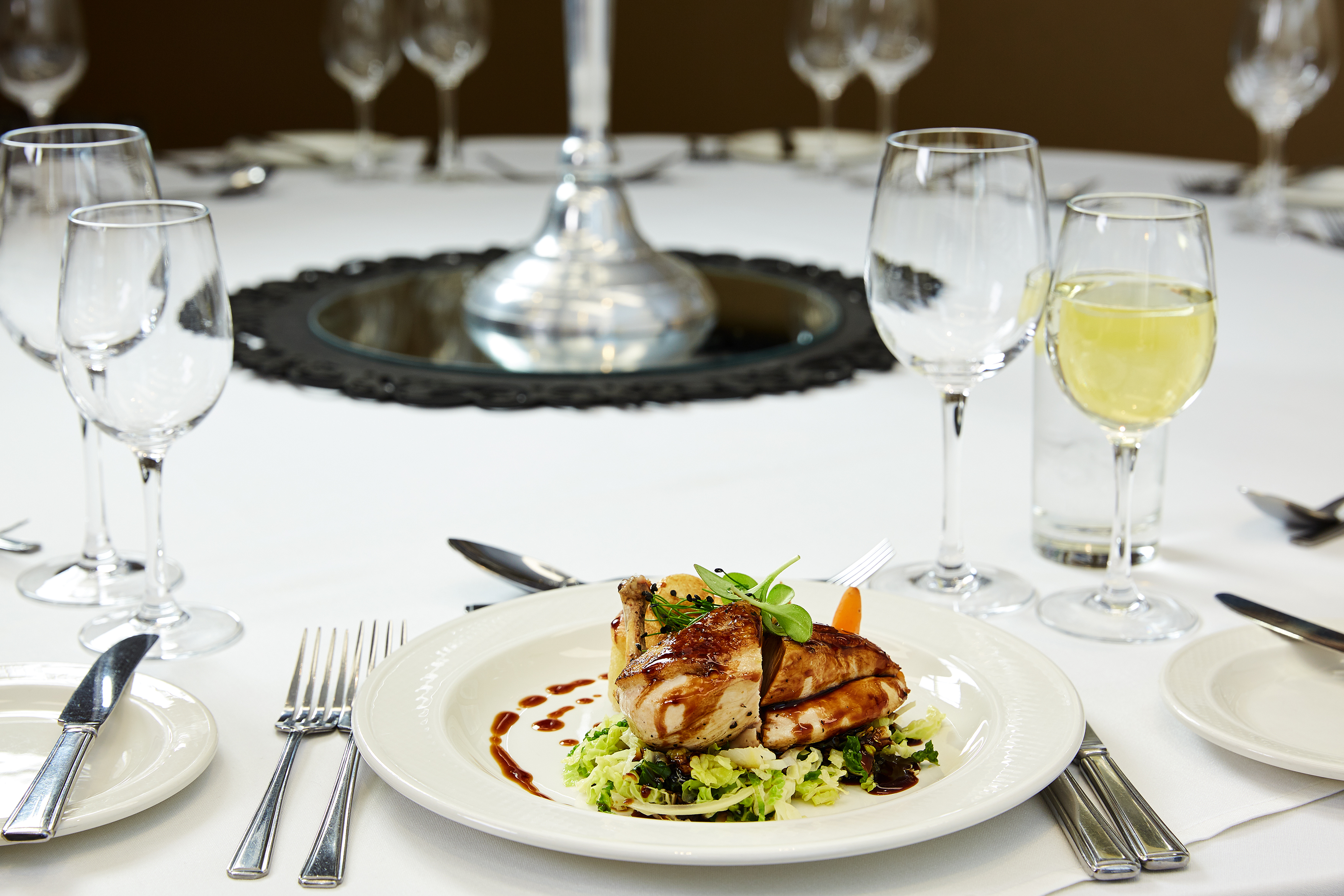 Elegant dining table with grilled chicken at Charles and James Suites, perfect for upscale events.